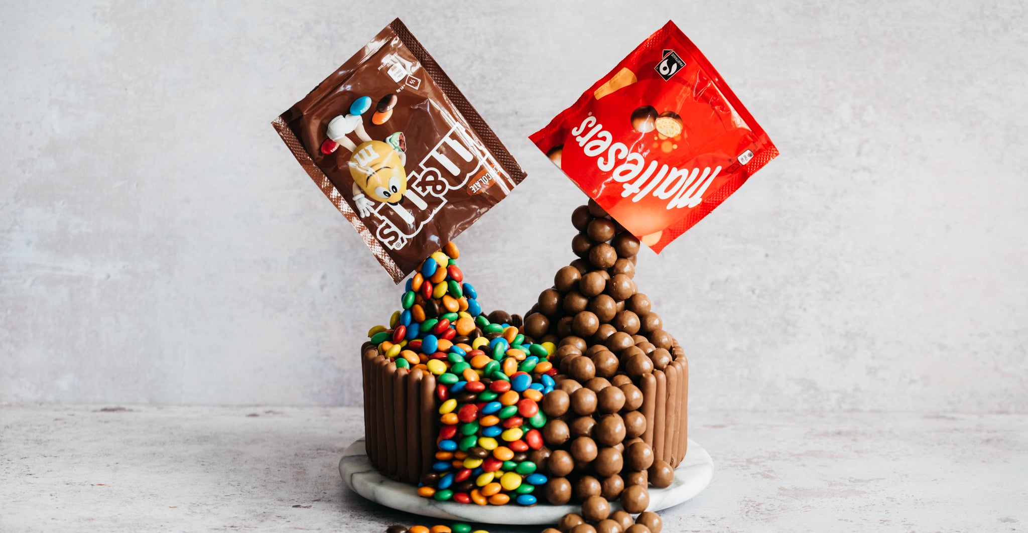 Chocolate Showstopper Cake with a bag of M&M's and Maltesers defying gravity 