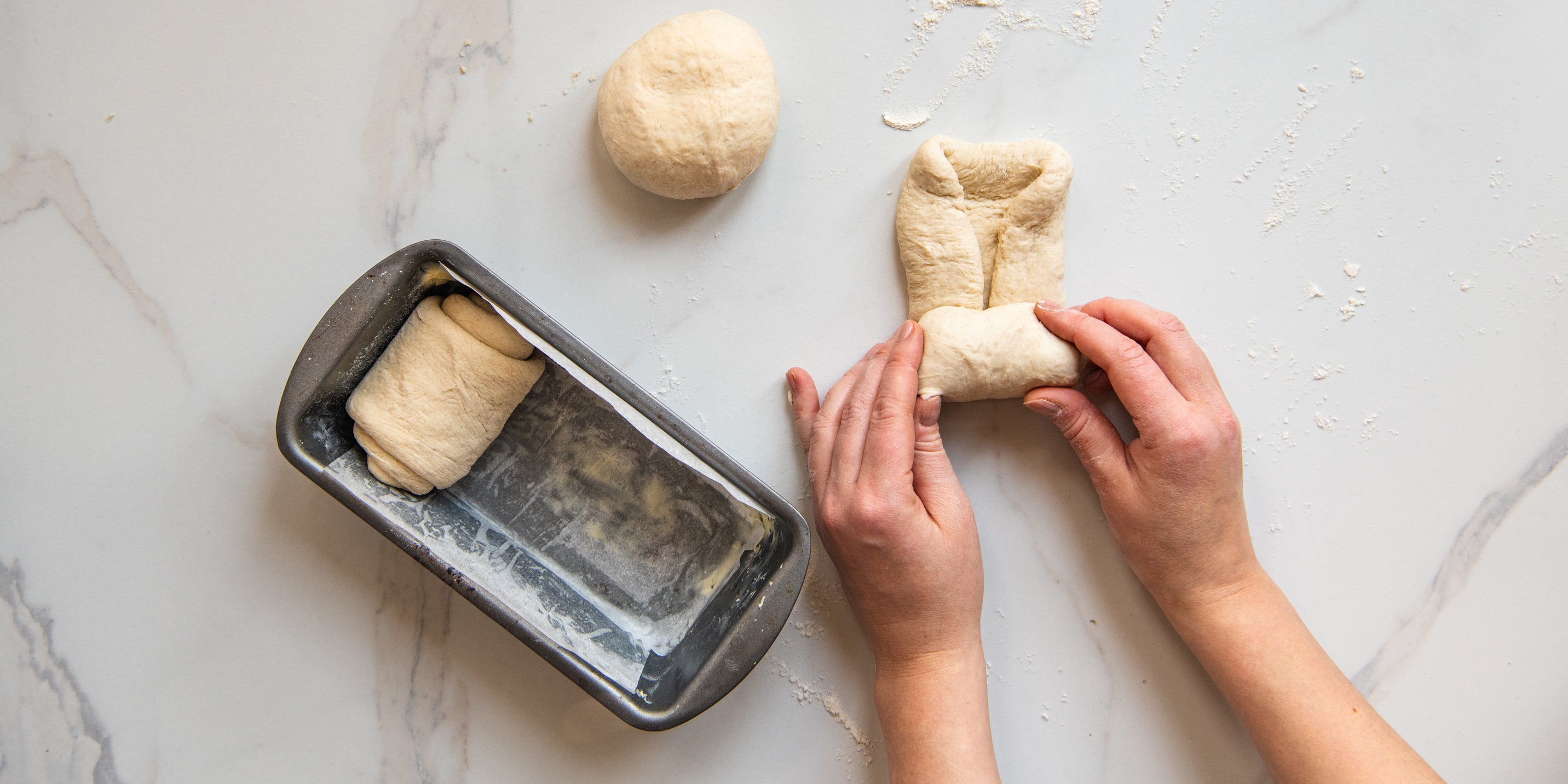 Shokupan Milk Bread being rolled into shapes ready to prove in the bread tin