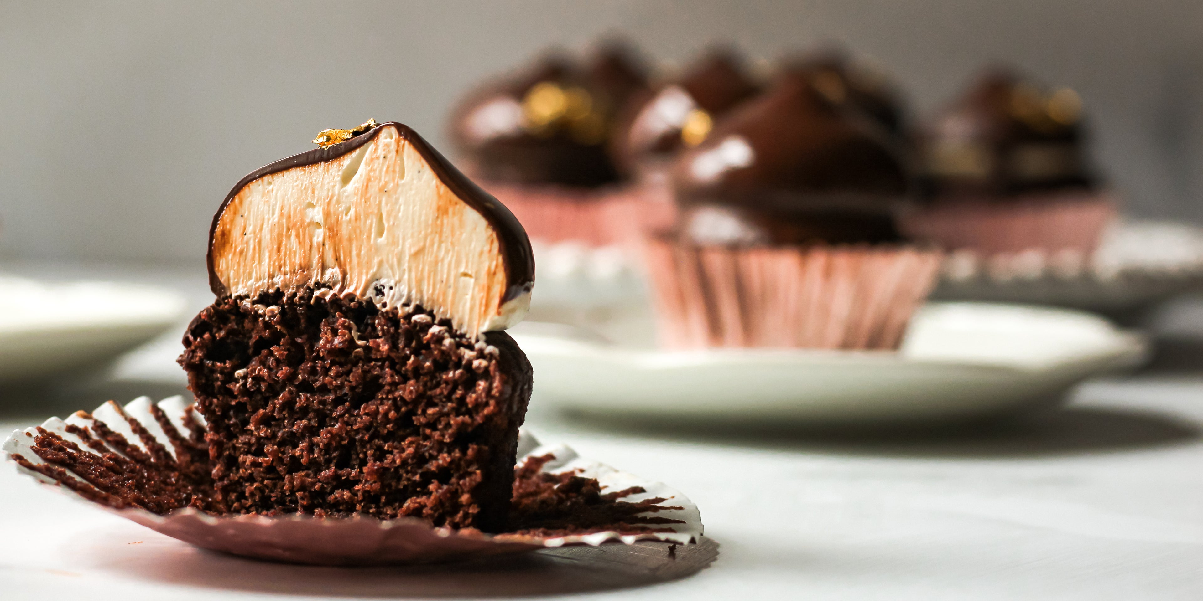 Close up of a Hi-Hat Cupcake cut in half, showing the fluffy swiss meringue buttercream filling