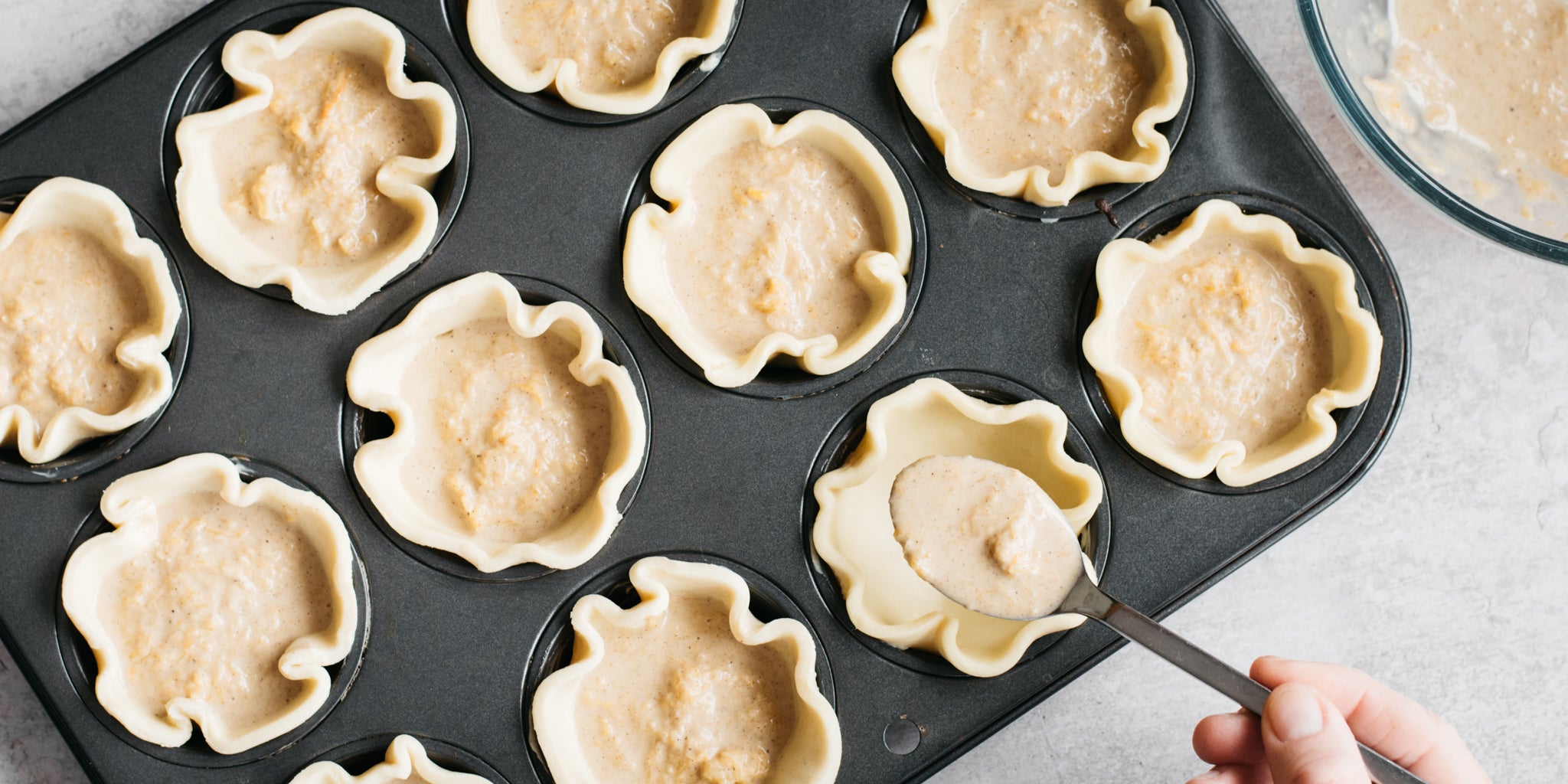 Hand sprinkling sugar on top of pastry p[ies