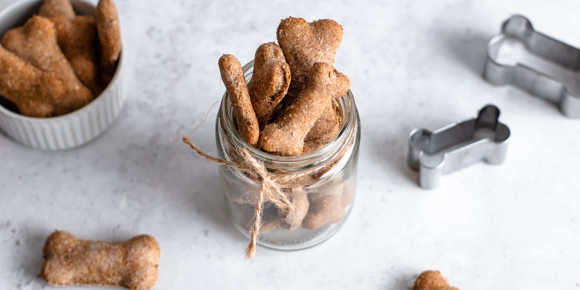 Dog Biscuits in a glass jar hand tied with twine, with dog biscuit cookie cutters
