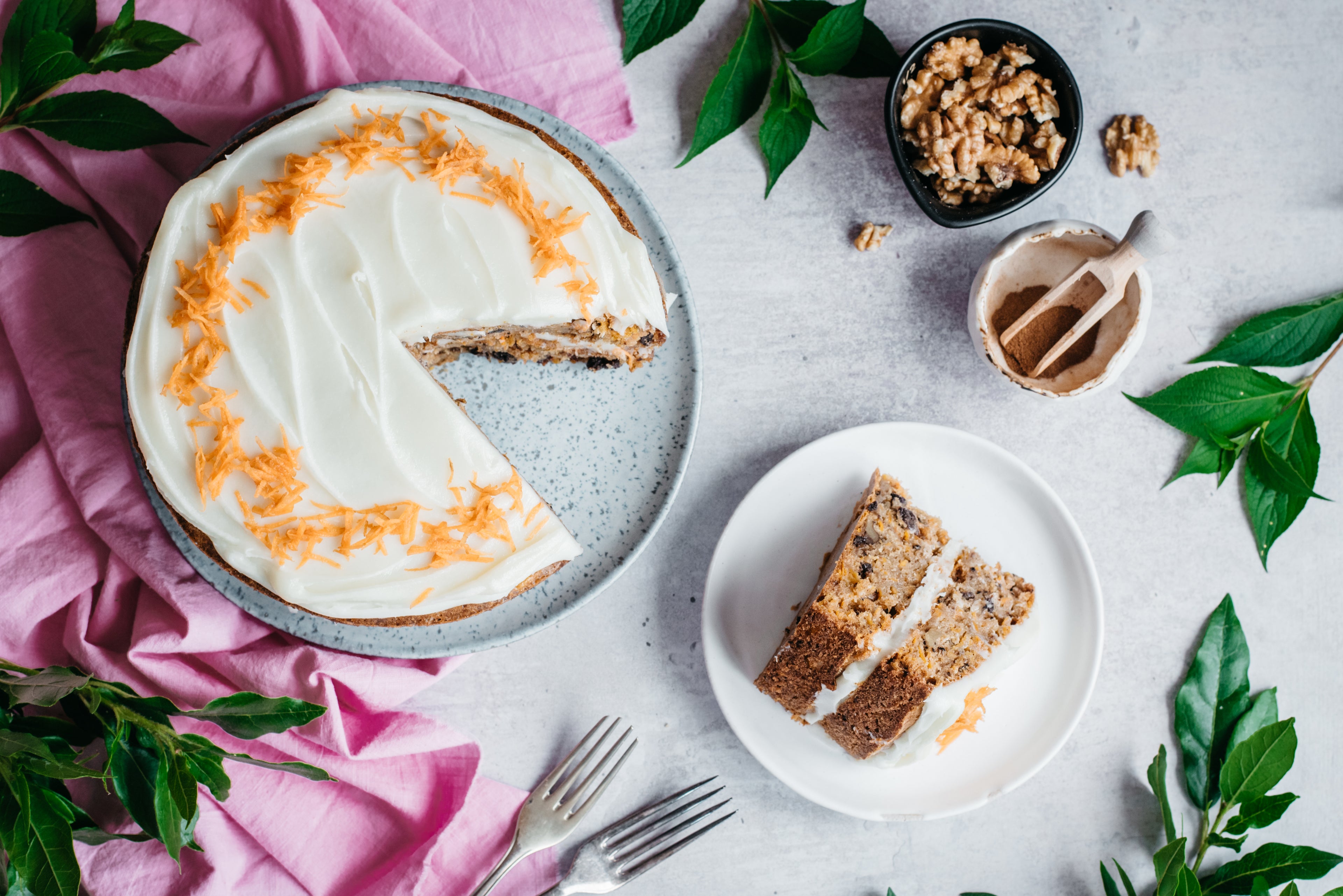 Top down view of a low sugar carrot cake with a slice cut out on a plate next to it
