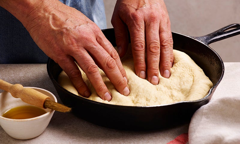 Pressing Deep Pan Pizza dough into a pizza pan