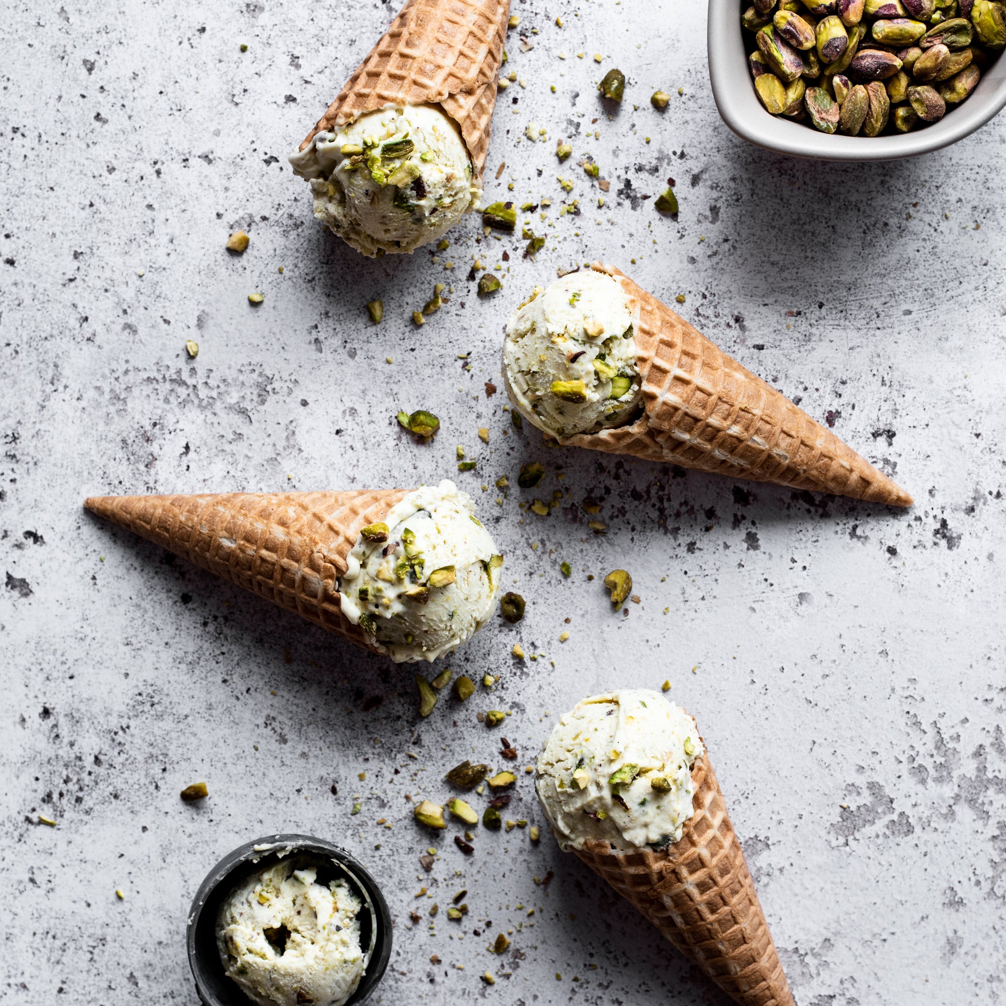 Four ice cream cones filled with homemade pistachio ice cream
