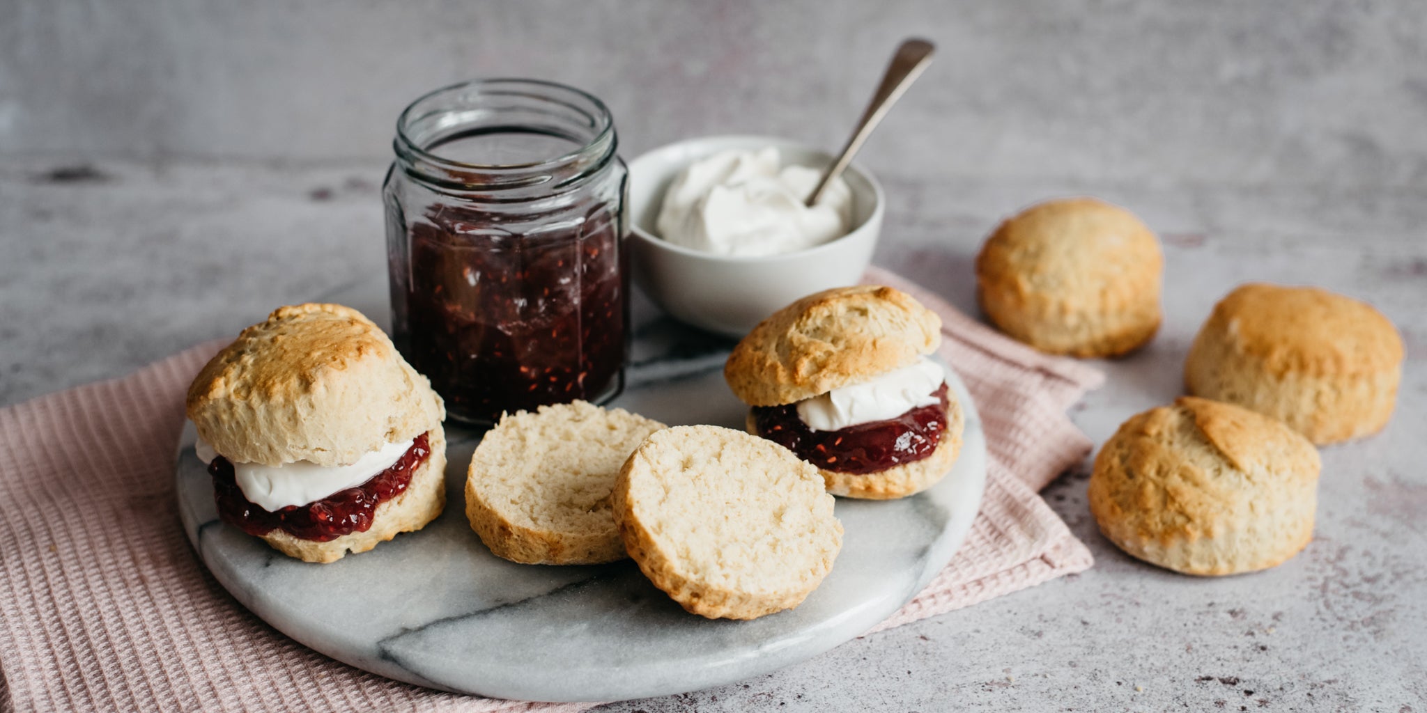 Vegan Scones cut in half ready to spread on some strawberry jam and a dollop of plant based cream