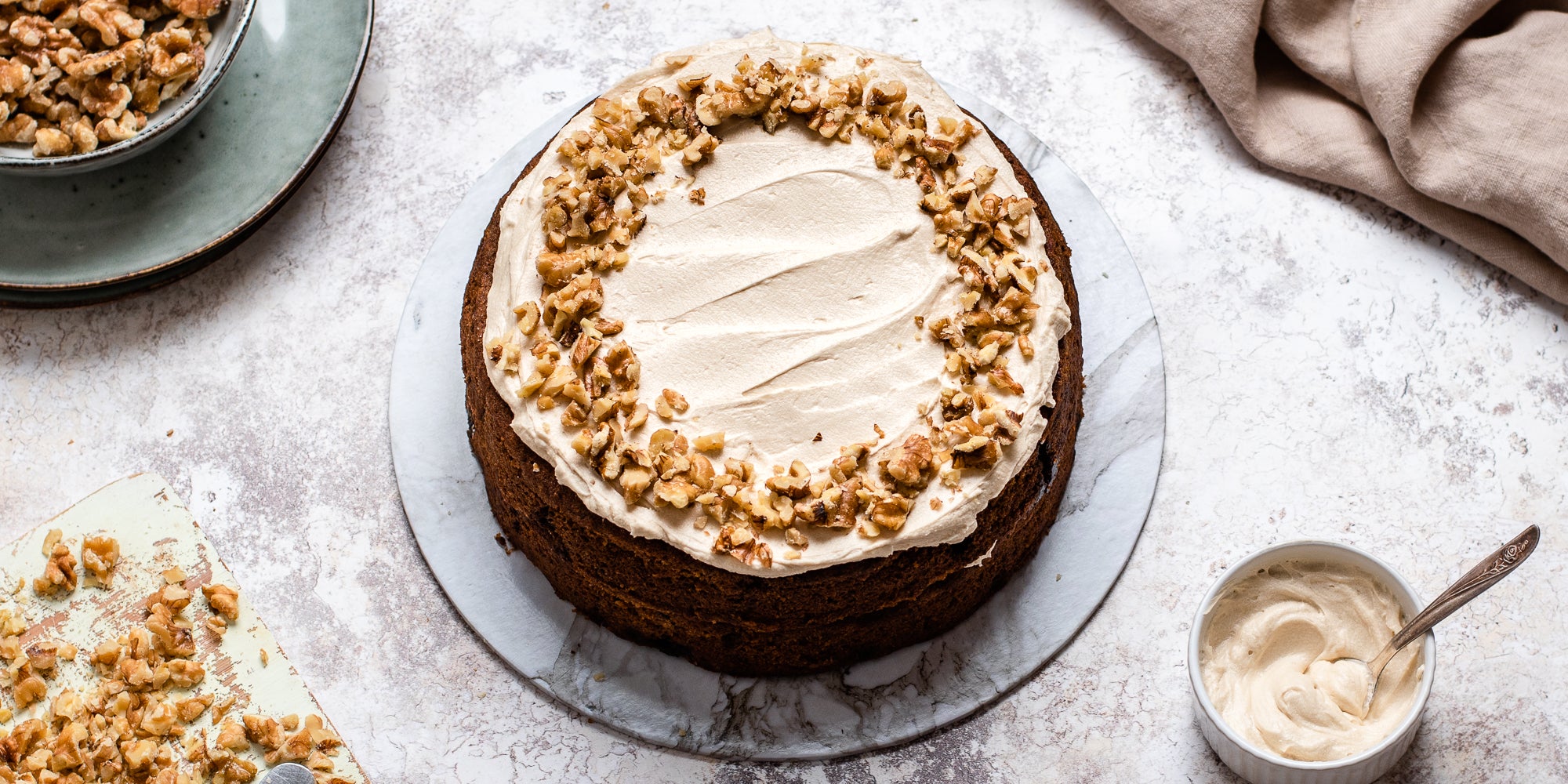 Gluten Free Vegan Coffee Cake hand decorated with chopped nuts and buttercream