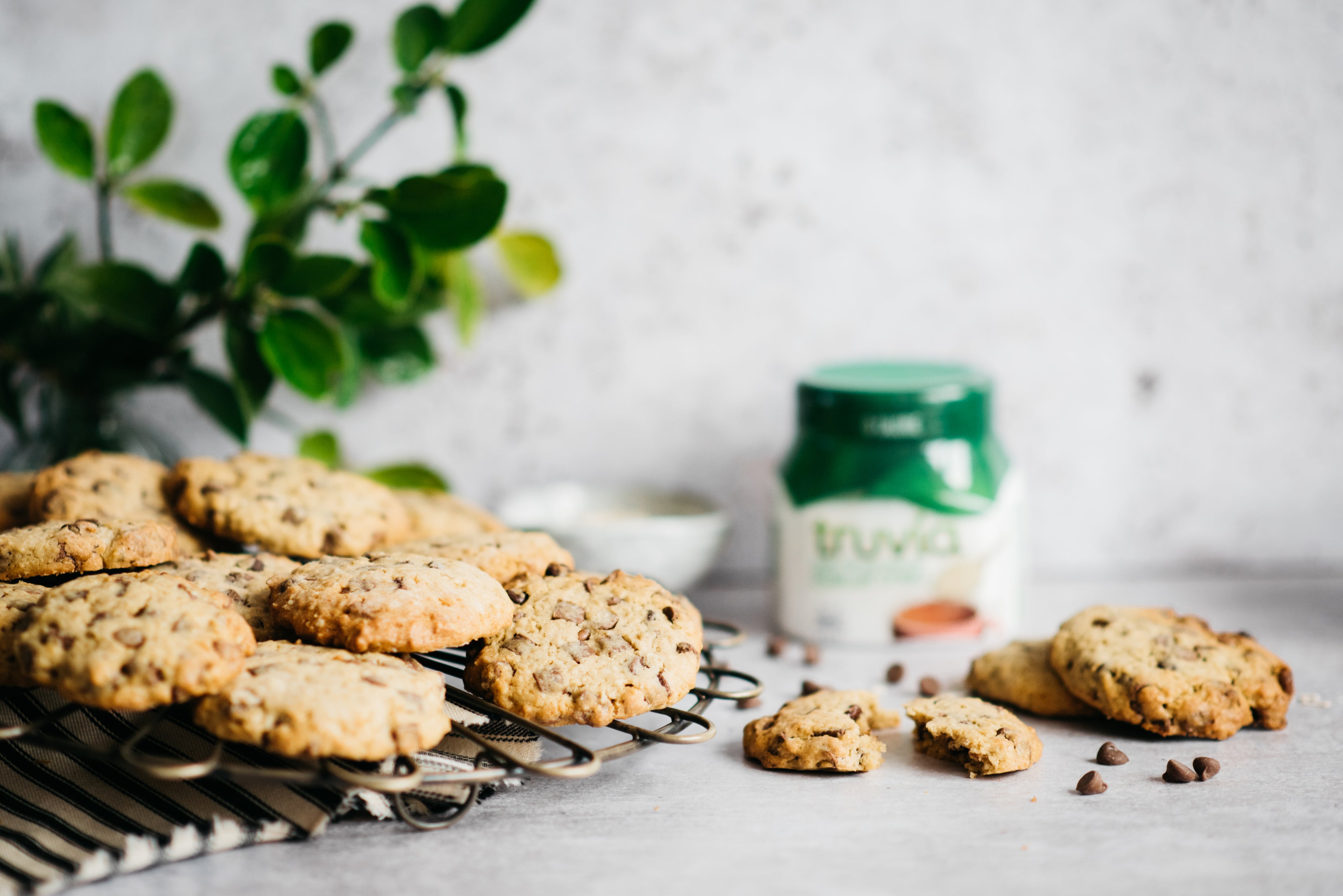Cookies on a cooling rack with chocolate chips scattered on table
