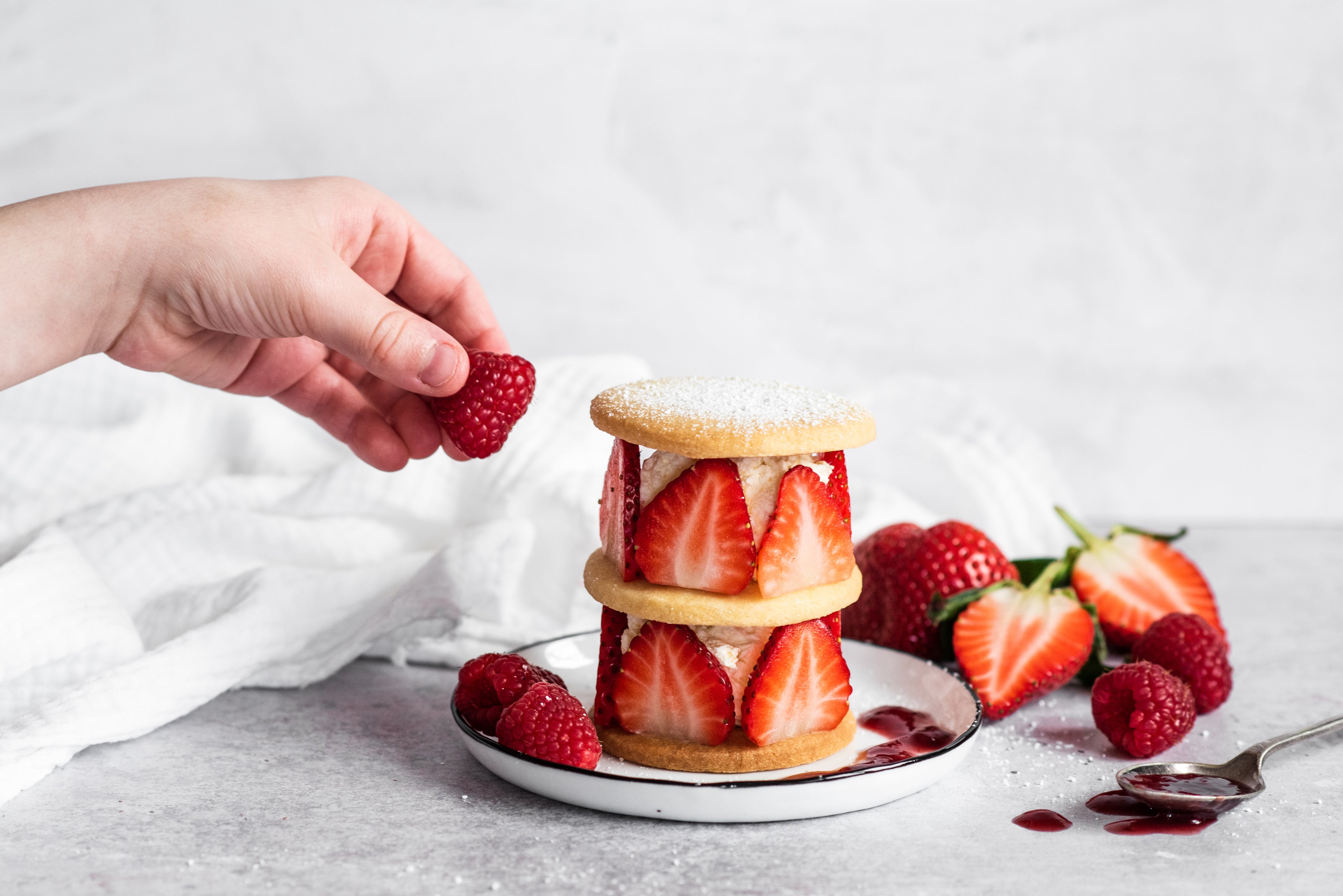 Shortbread rounds with sliced strawberries and cream sandwiched between