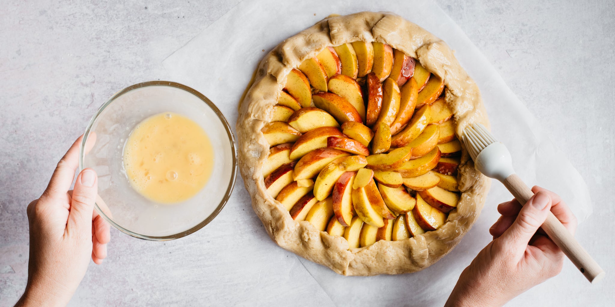 Peache galette being brushed with melted butter