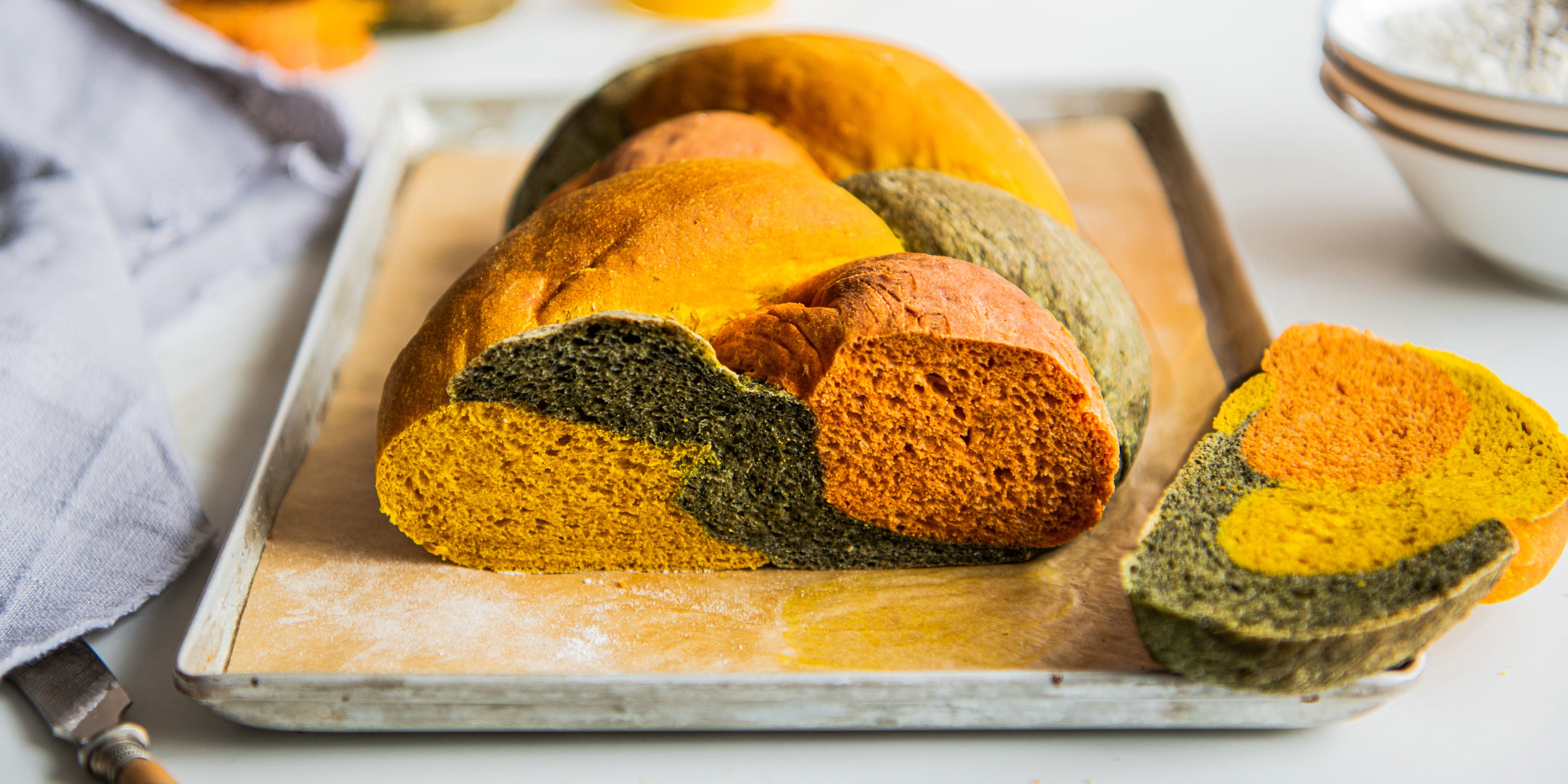 Close up of a sliced plaited tri colour loaf on a baking tray