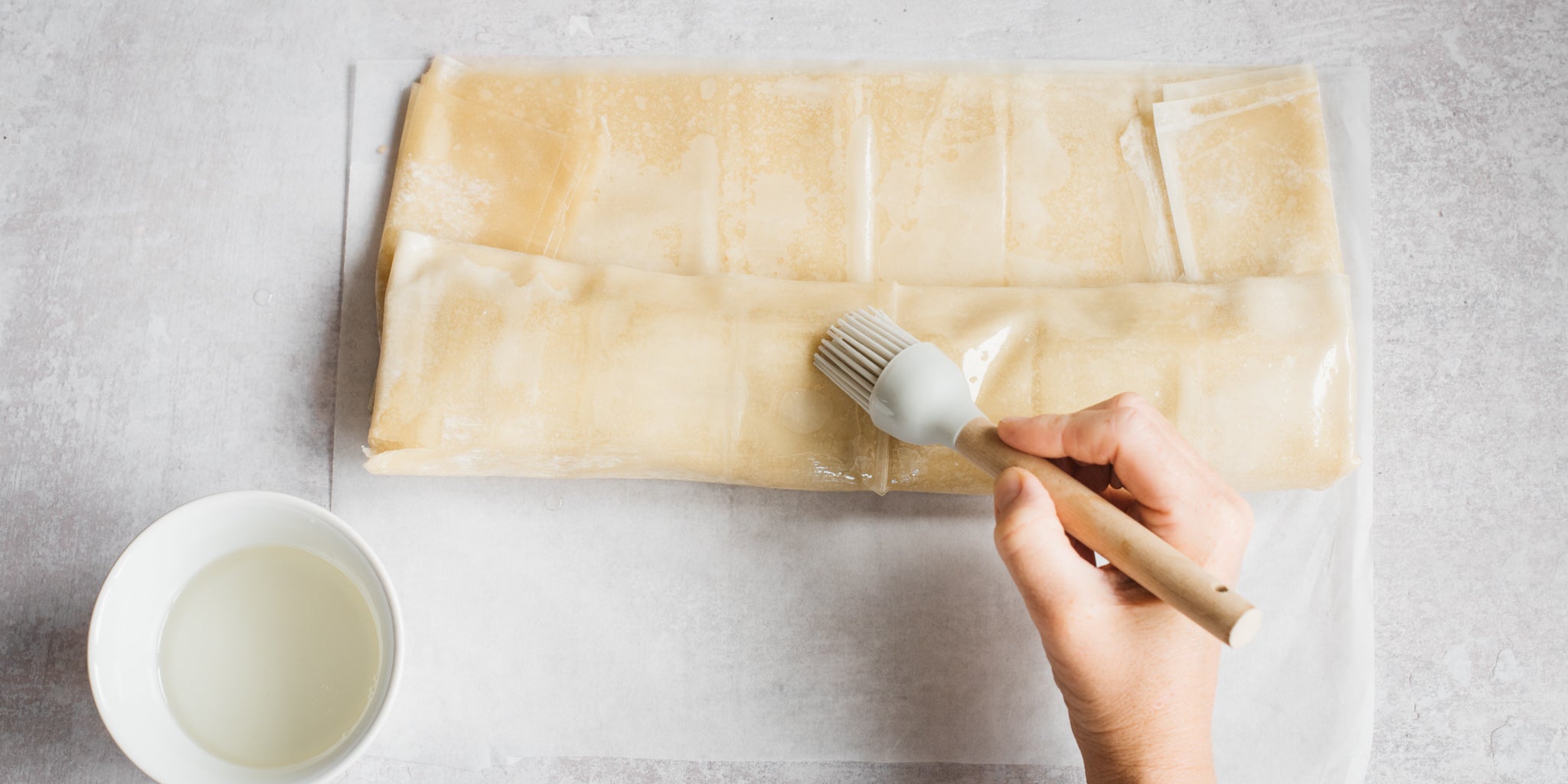 Hand brushing milk onto pastry