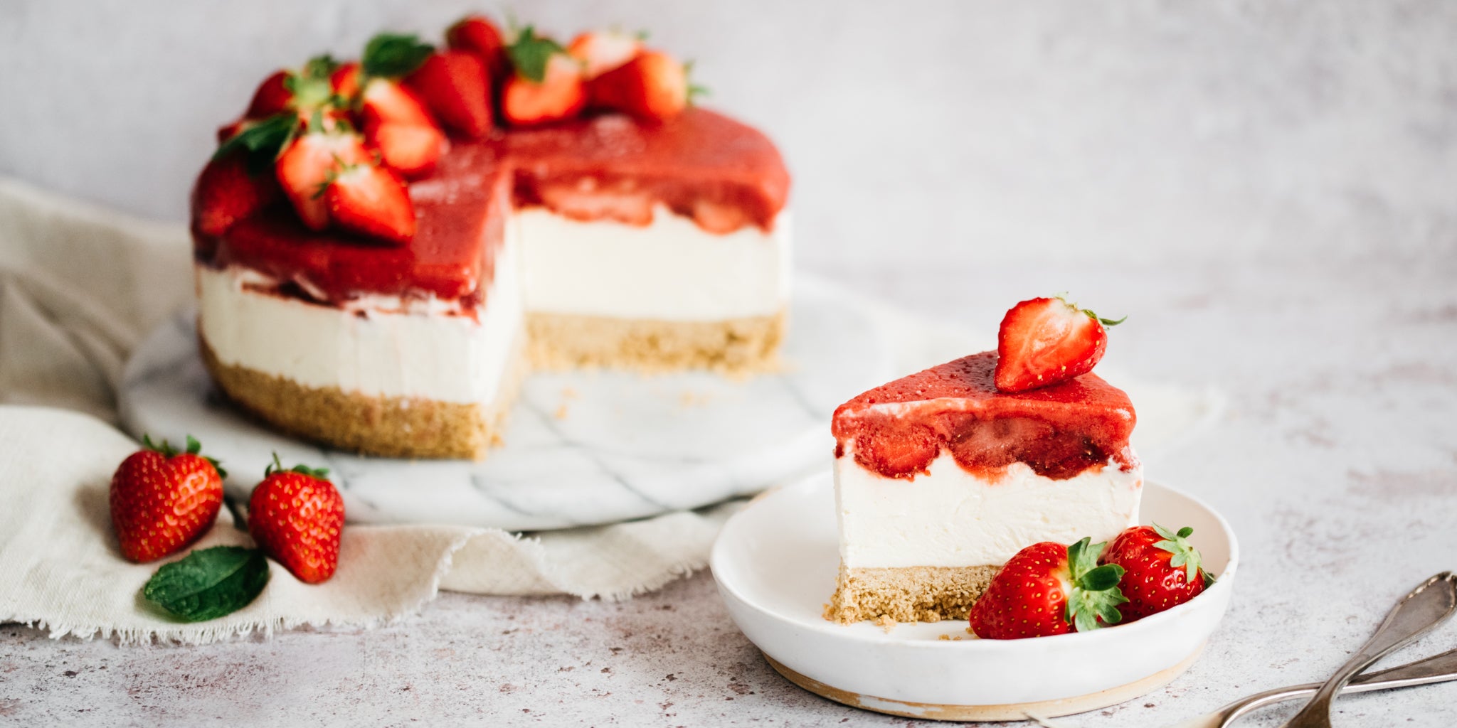 Slice of cheesecake in forefront with remaining cheesecake on plate in background