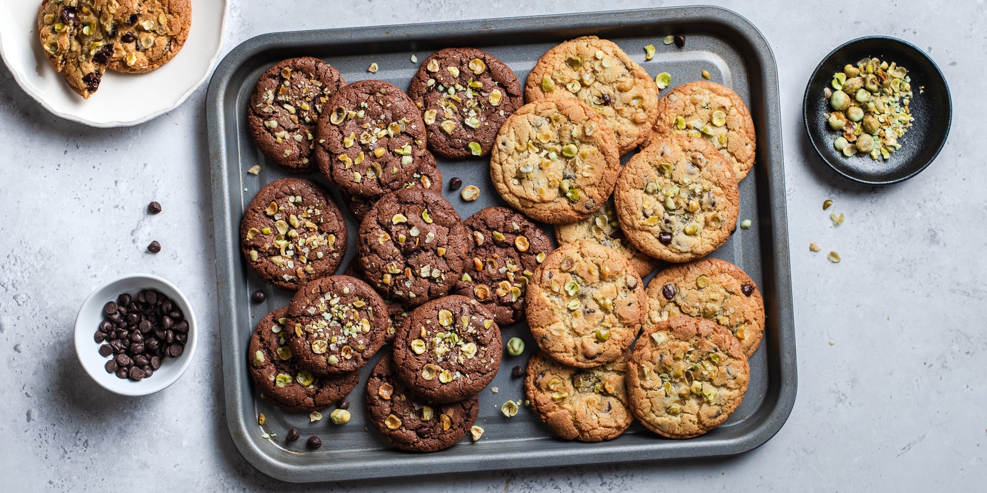 Top down view of a batch of wasabi cookies on a baking tray surrounded by ingredients 