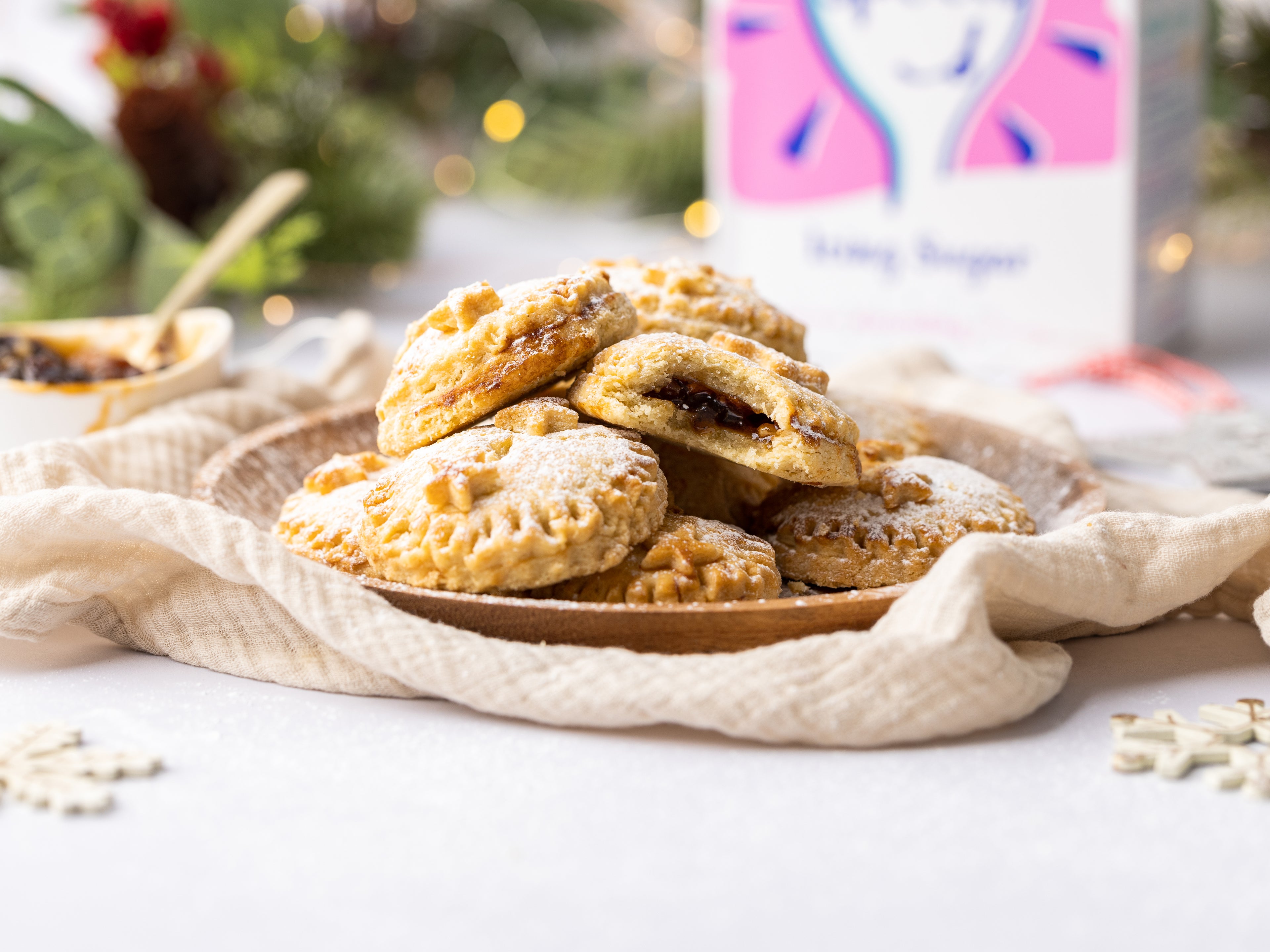 Stack of mince pies on a plate, one with a bite taken out of it