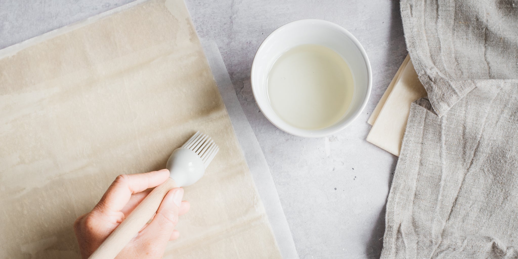 Hand brushing pastry with milk