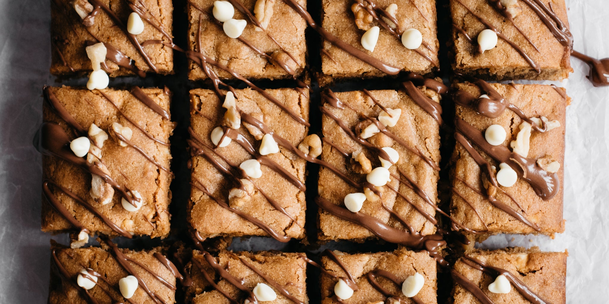 Close up overhead shot of peanut butter blondies sprinkled with white chocolate chips and drizzled in melted chocolate