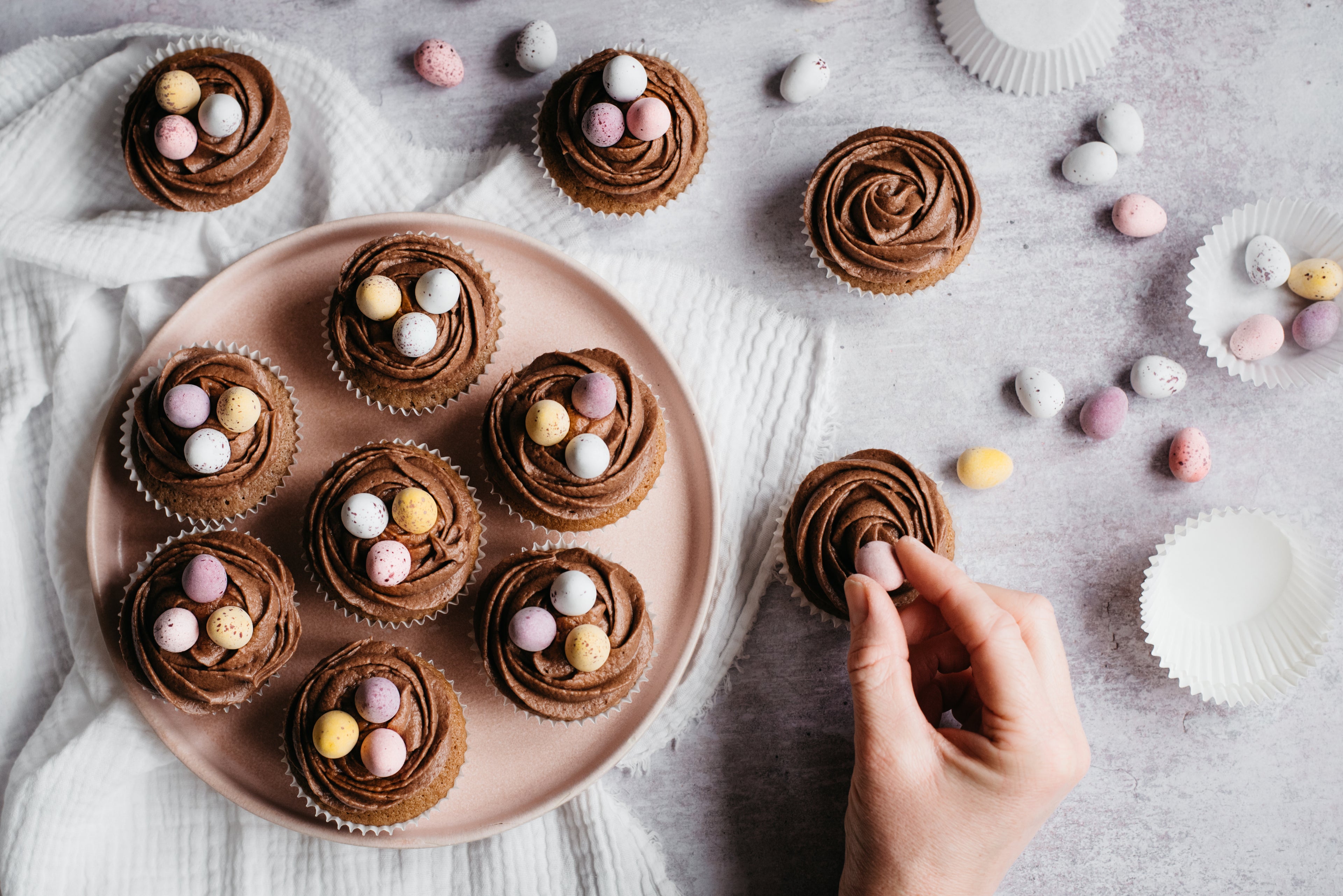 birds-eye view of cupcakes topped with chocolate icing and mini eggs