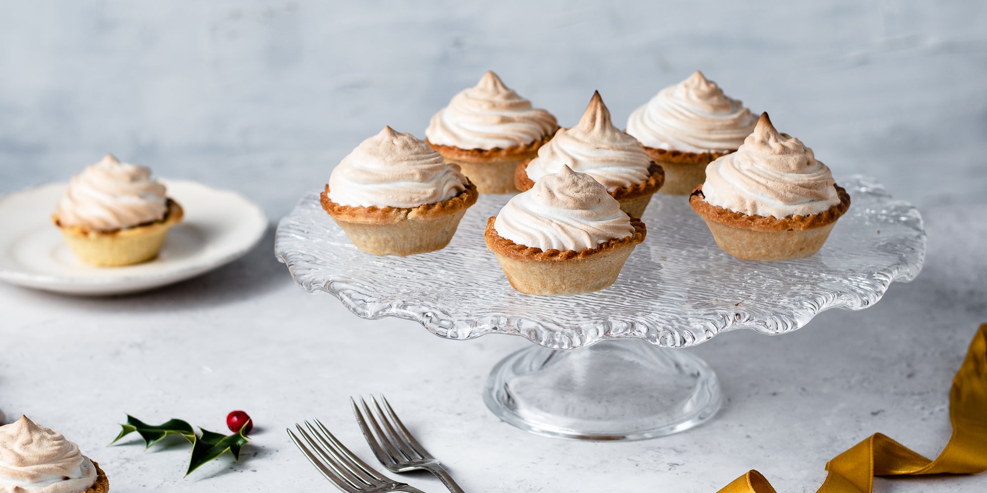 Close up of Meringue Topped Mince Pies on a glass cake stand