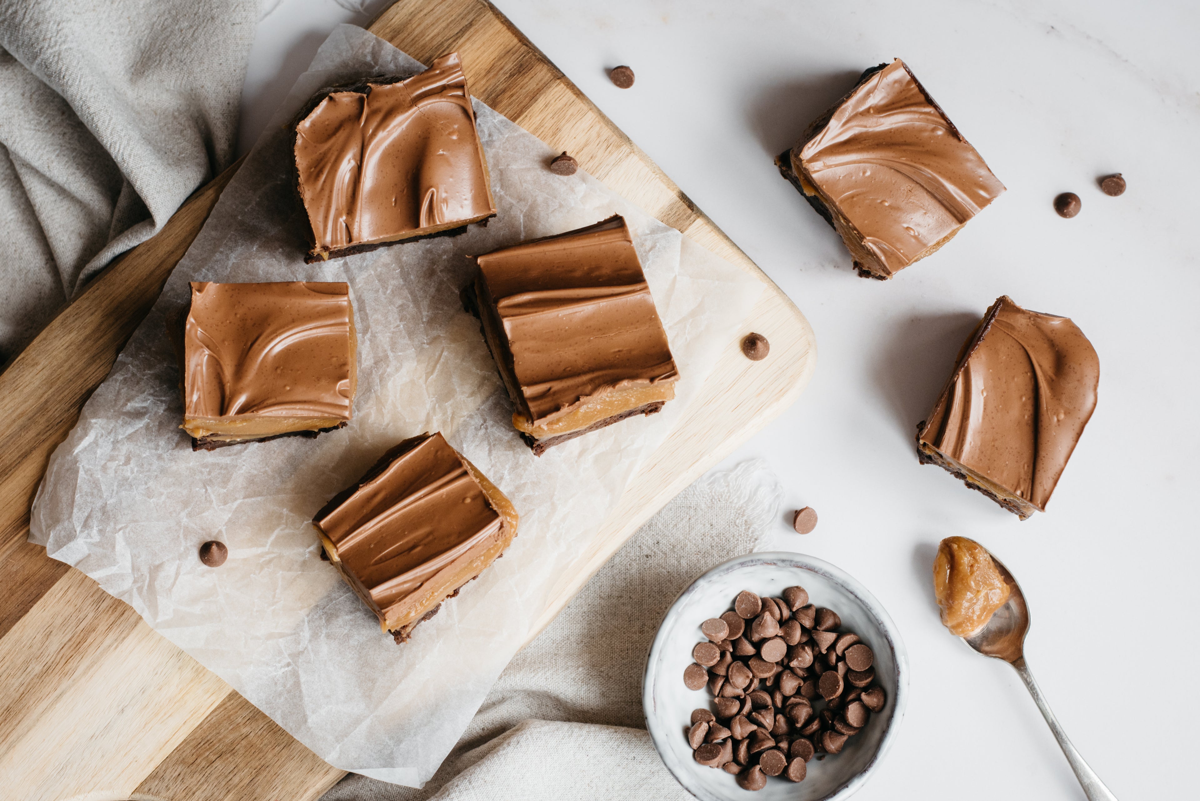 Flat lay of sliced Brownie Based Millionaires Traybake with chocolate chips