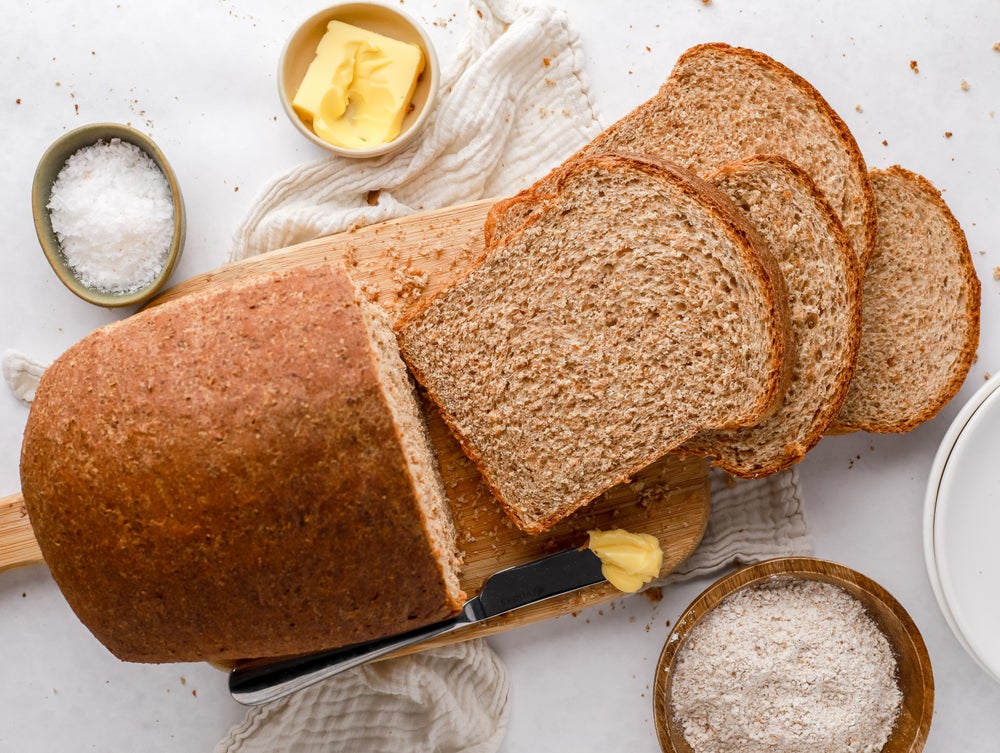 Loaf of wholemeal bread with slices infront of it.