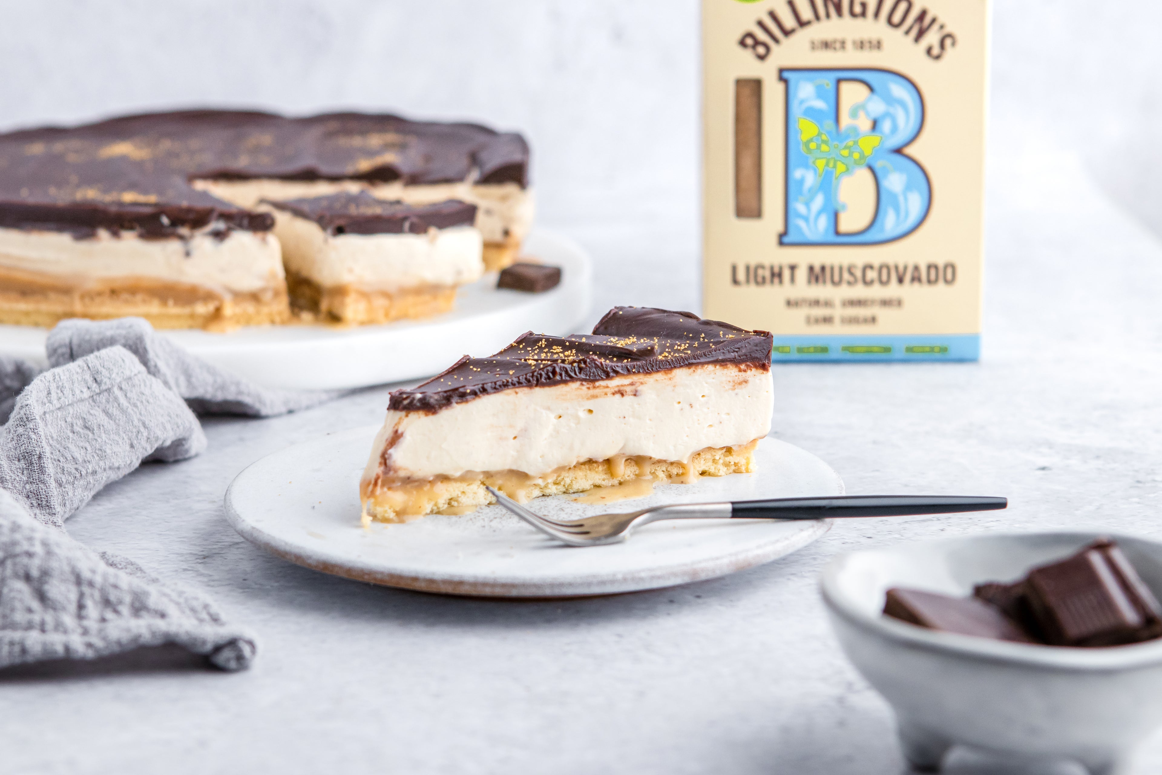 Millionaire's Cheesecake slice with a box of Billington's Light Muscovado Sugar in the background