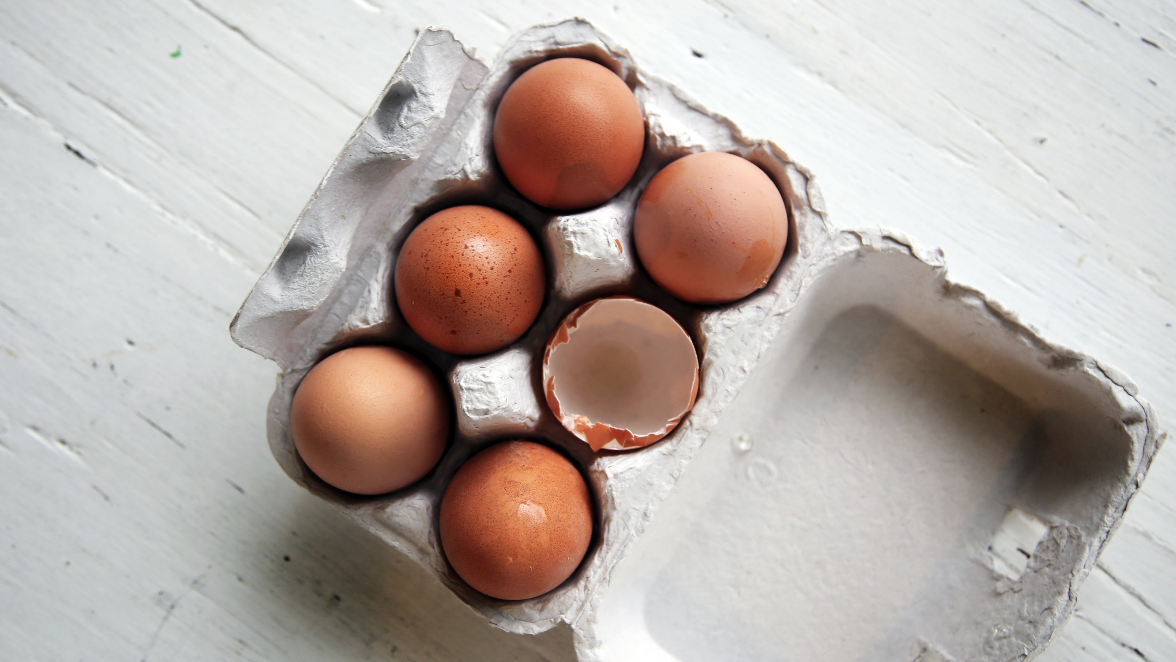 Pack of 6 eggs in a cardboard egg box against a white background