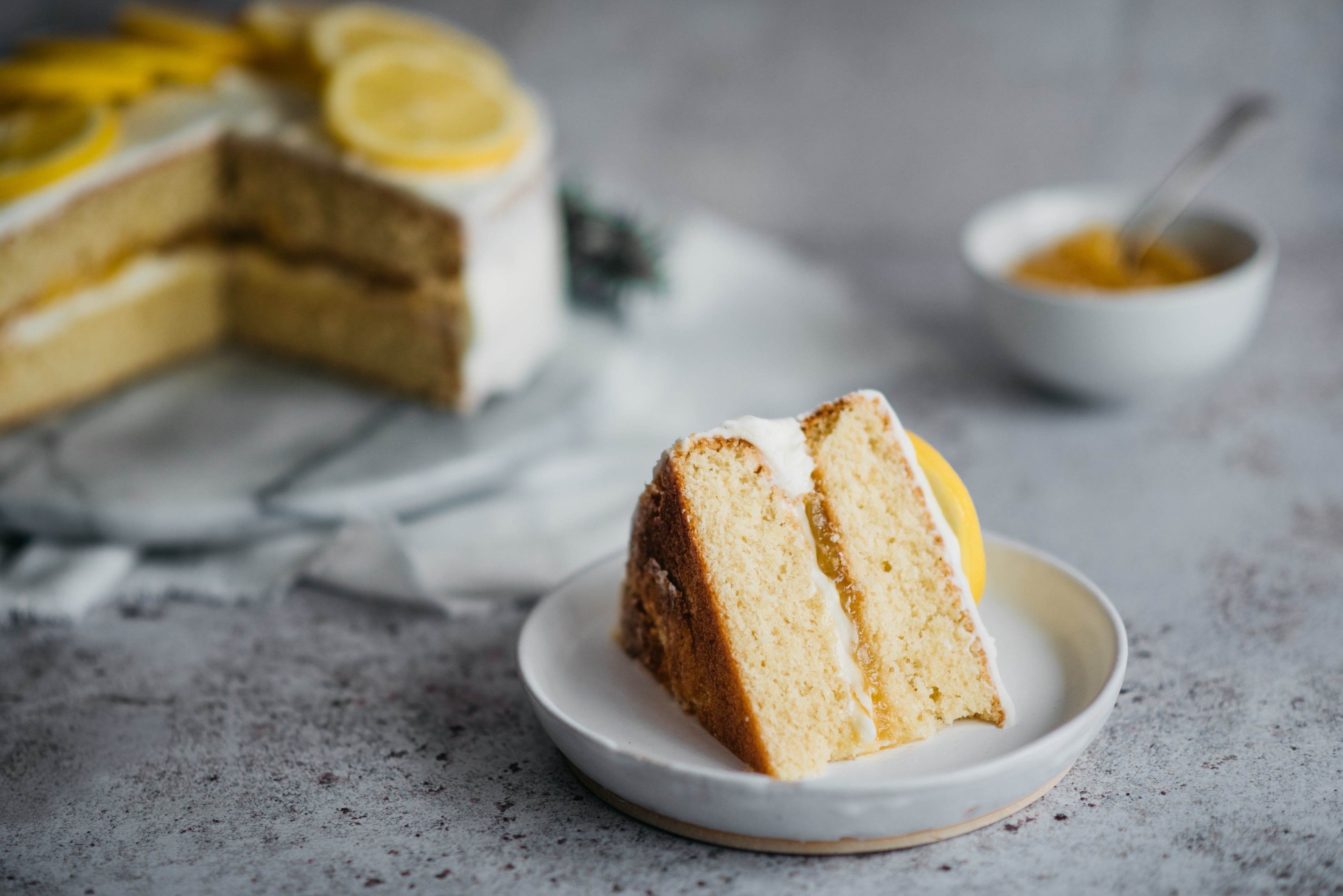 Close up of a slice of Gluten Free Elderflower & Lemon Cake on a plate