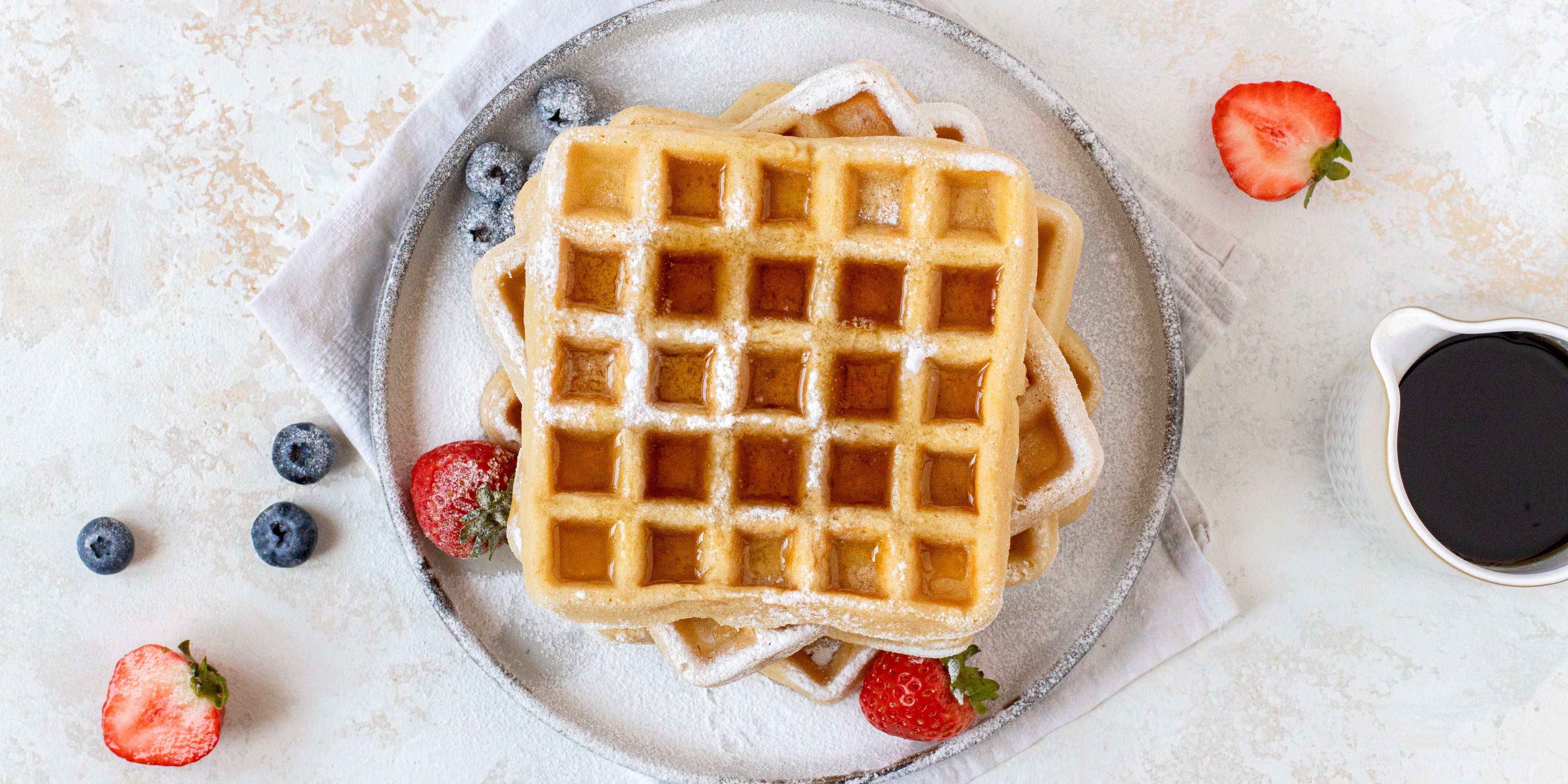 Top down view of vegan gluten free waffles topped in billington's syrup