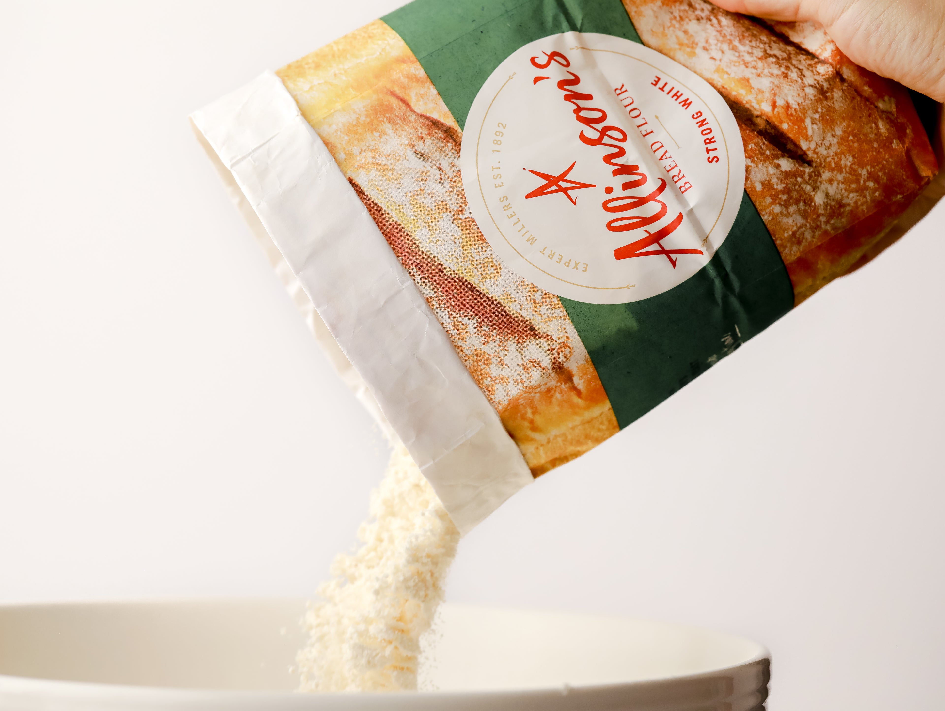 Bread flour being poured from a pack into a bowl