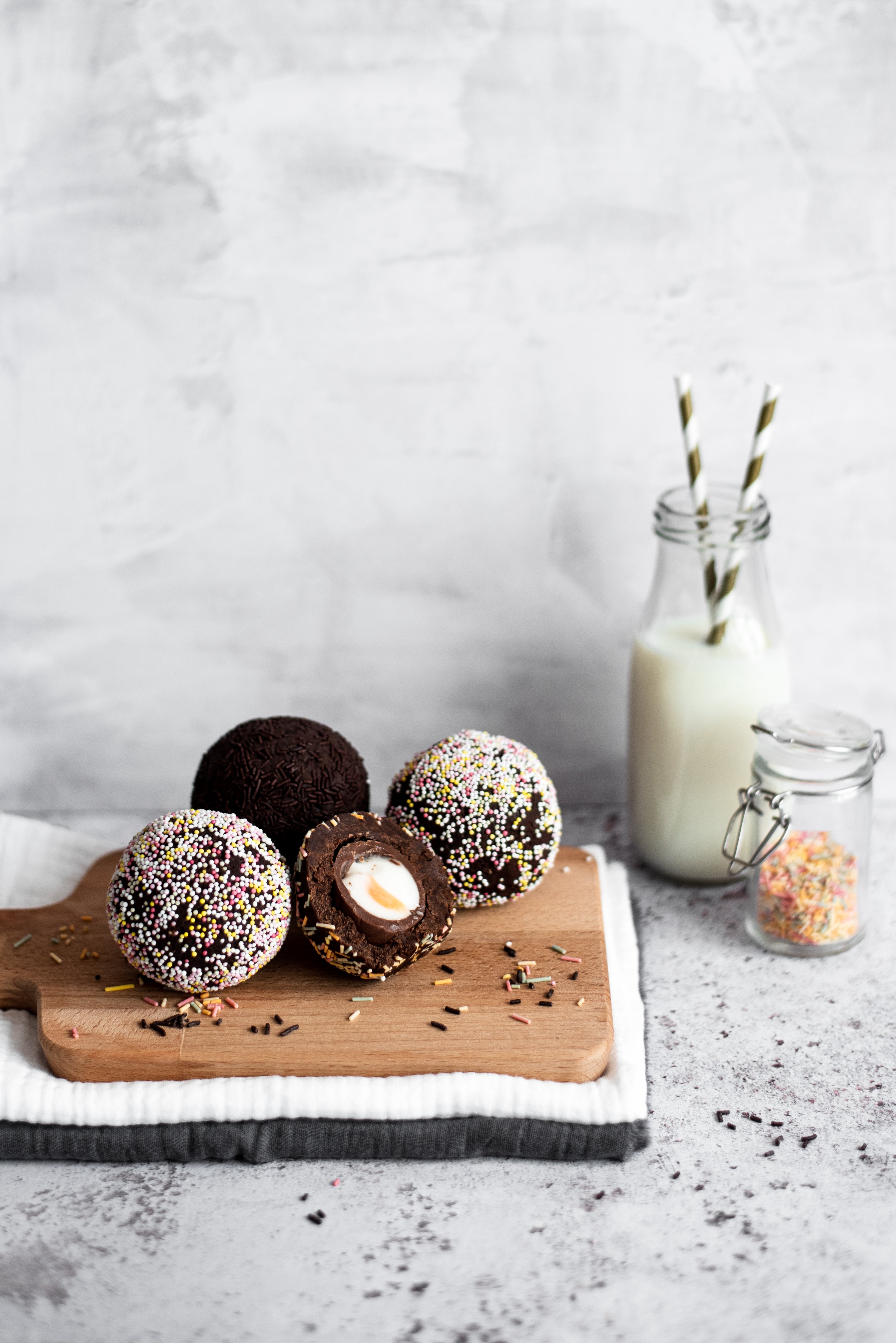 chocolate scotch egg cut in half on a wooden board