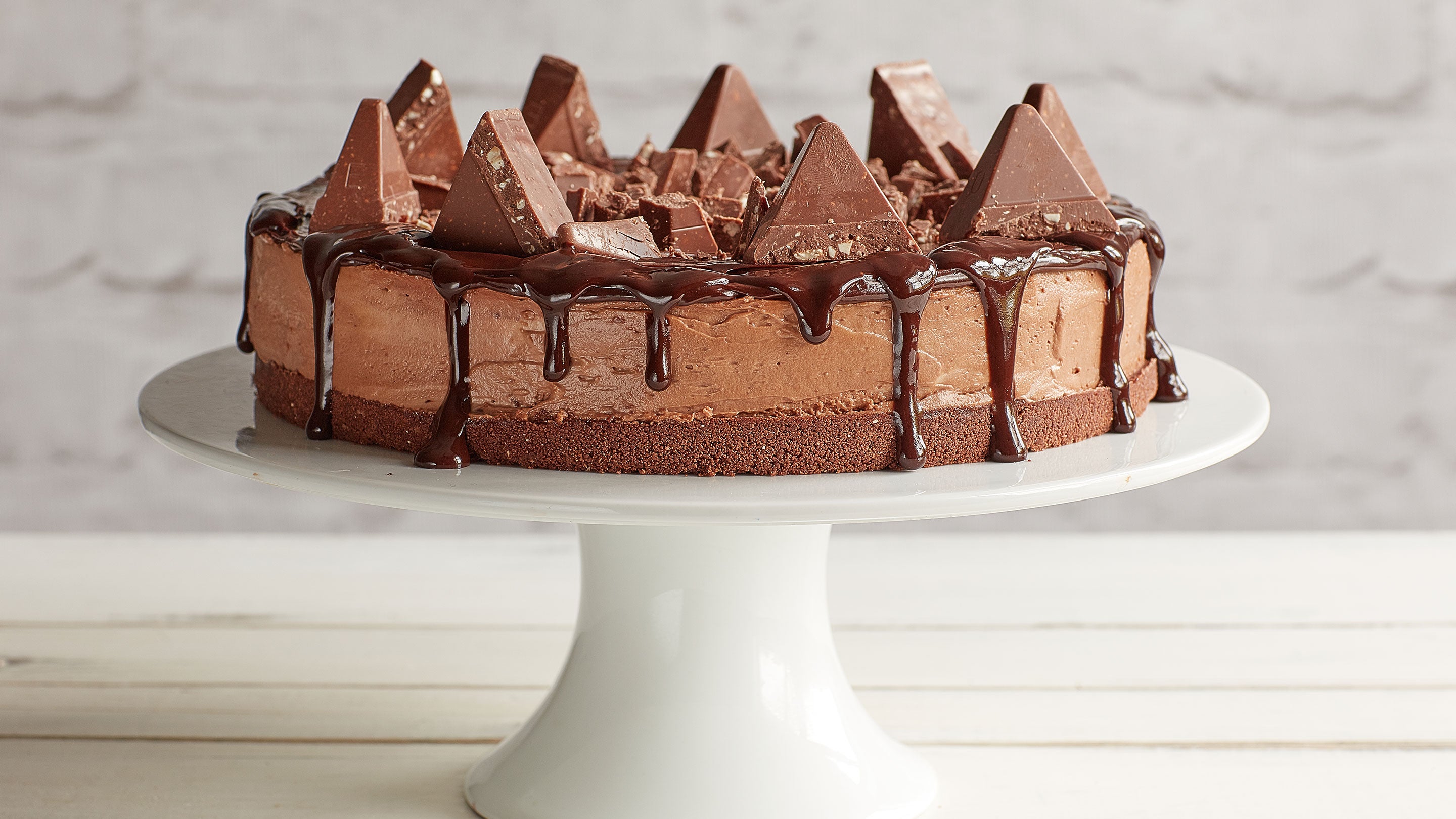 Toblerone cheesecake topped with Toblerone triangles on a white cake platter