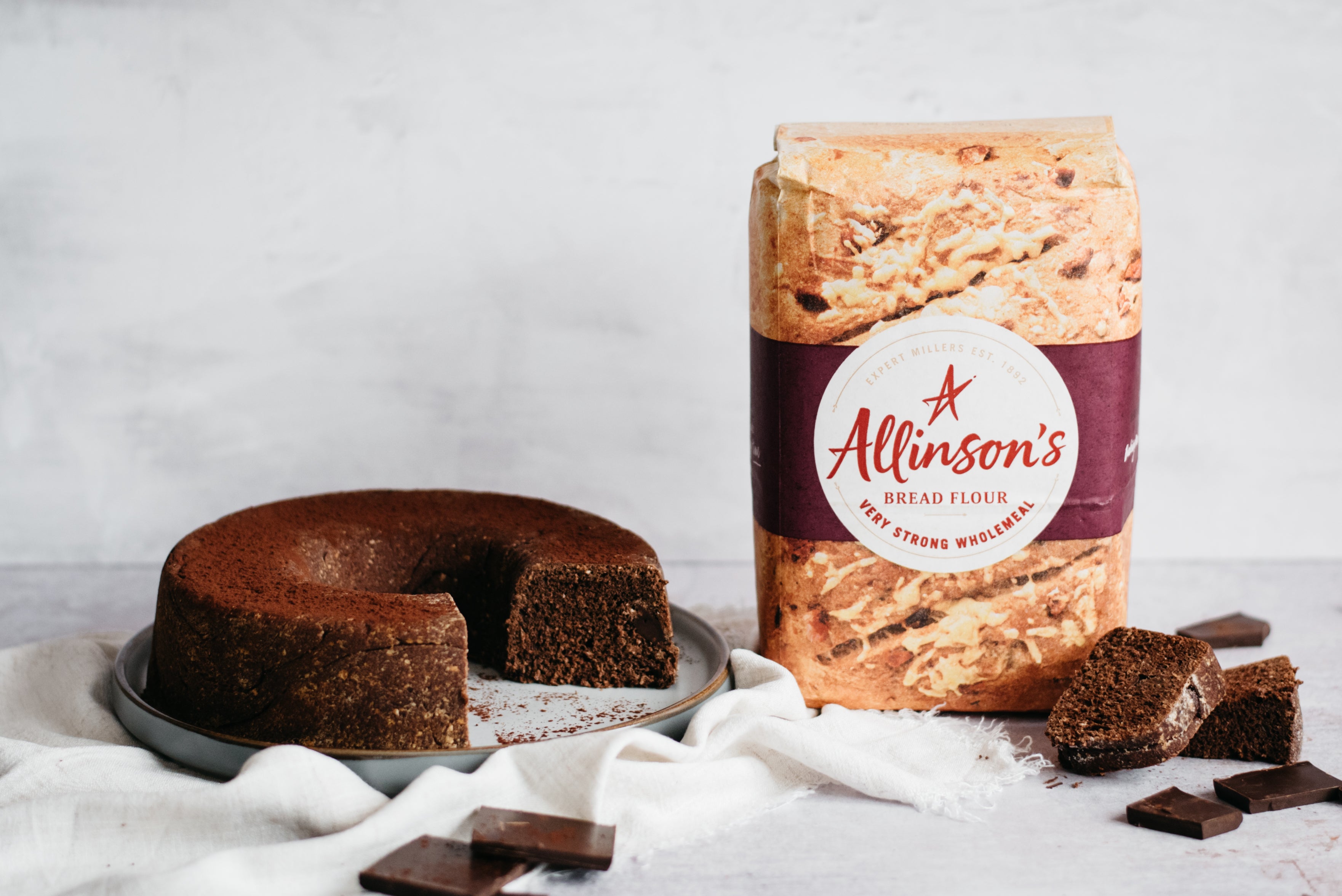 Chocolate Bread next to a bad of Allinson's Very Strong Wholemeal flour next to slices of Chocolate Bread