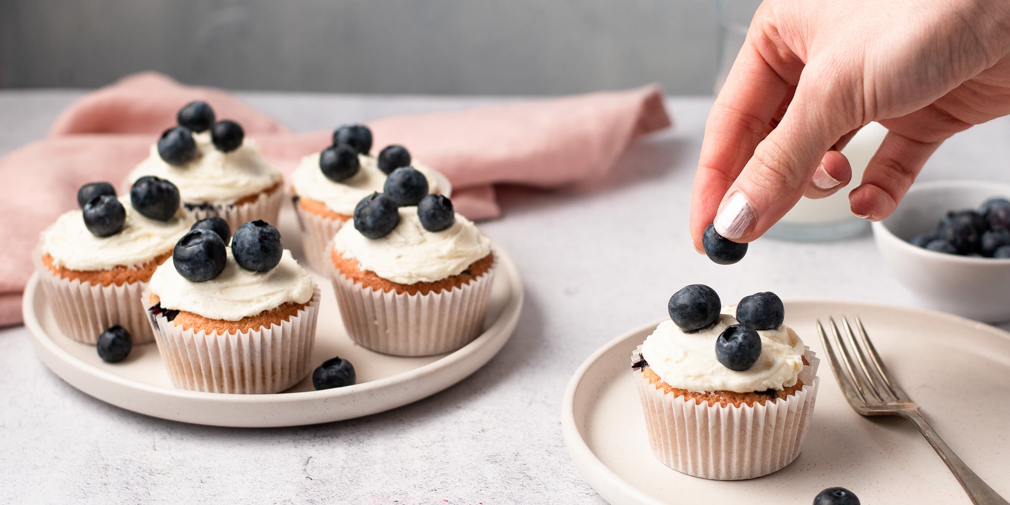 Cupcakes topped with icing and blueberries