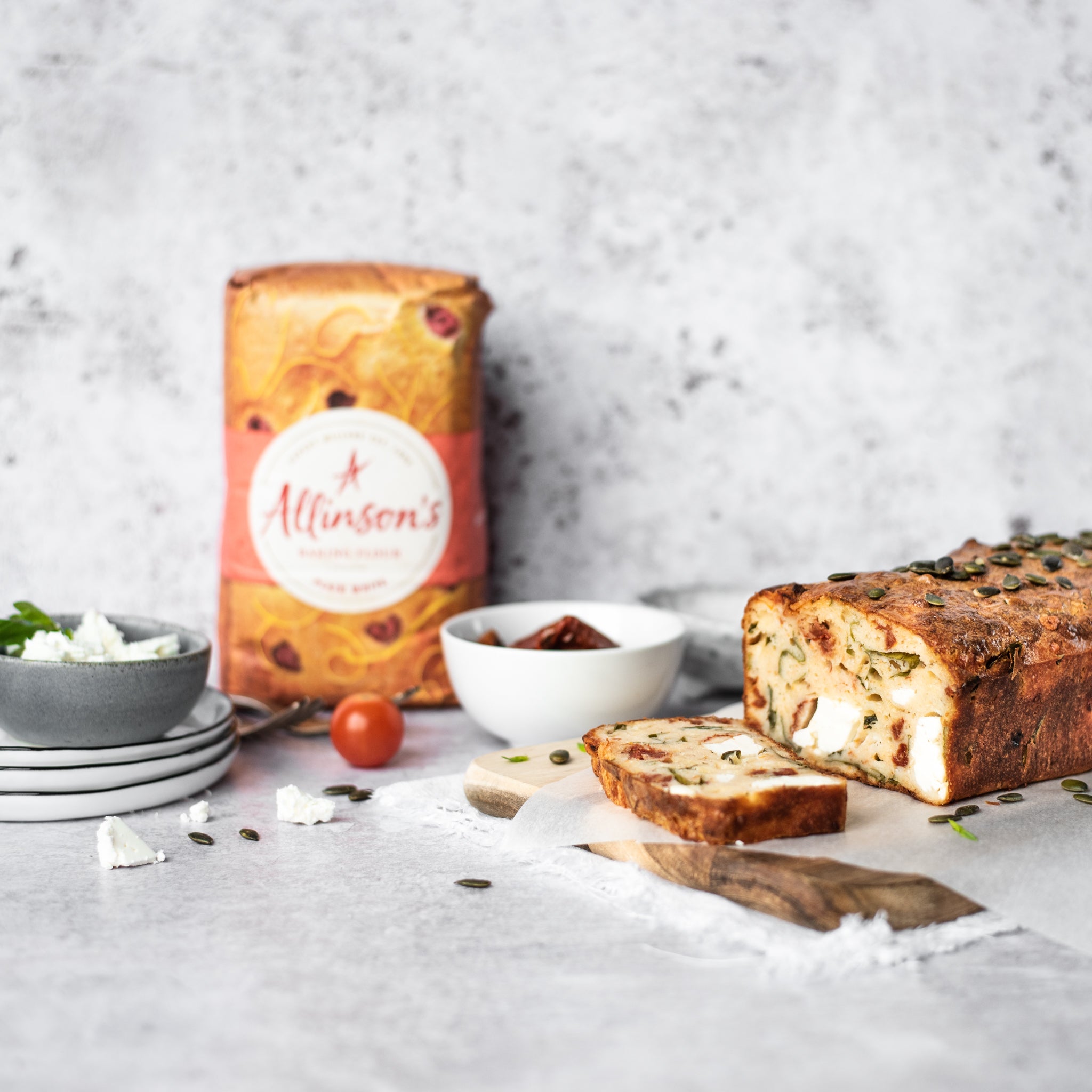 Feta and tomato loaf with slice removed on a chopping board