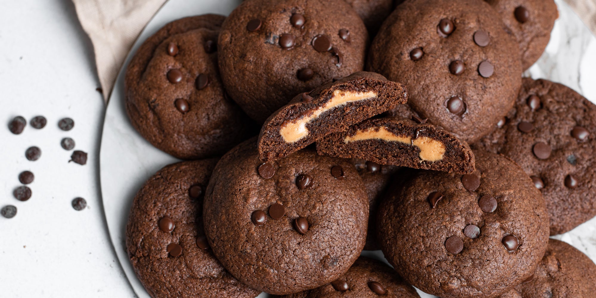 Close up Chocolate & Peanut Butter Stuffed Cookies with a cookie sliced in half.
