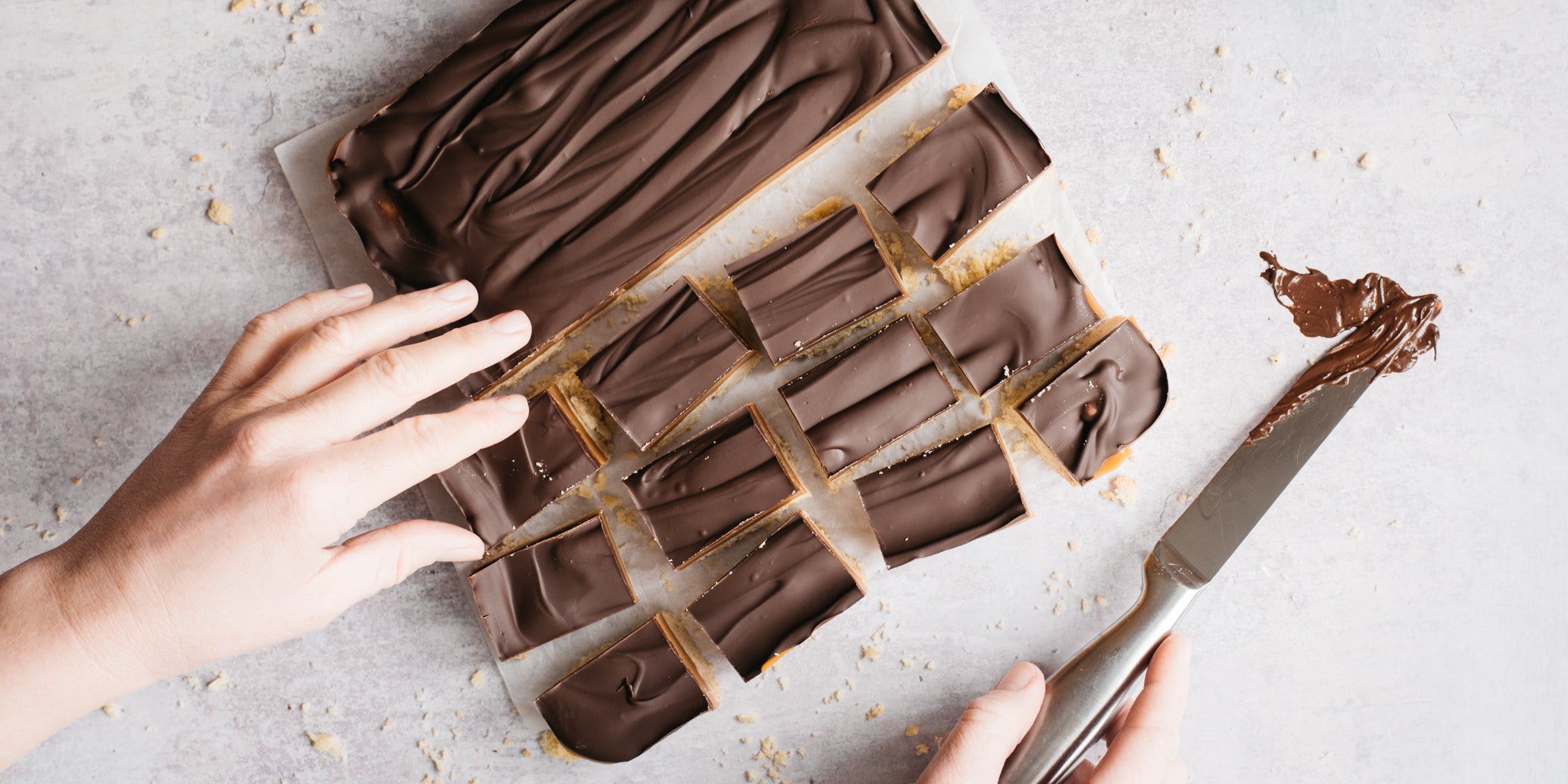 Hand cutting up millionaires shortbread with a knife