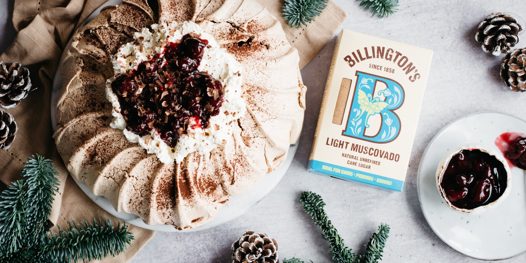 Top view of Black Forest Pavlova next to a box of billington's light muscovado sugar