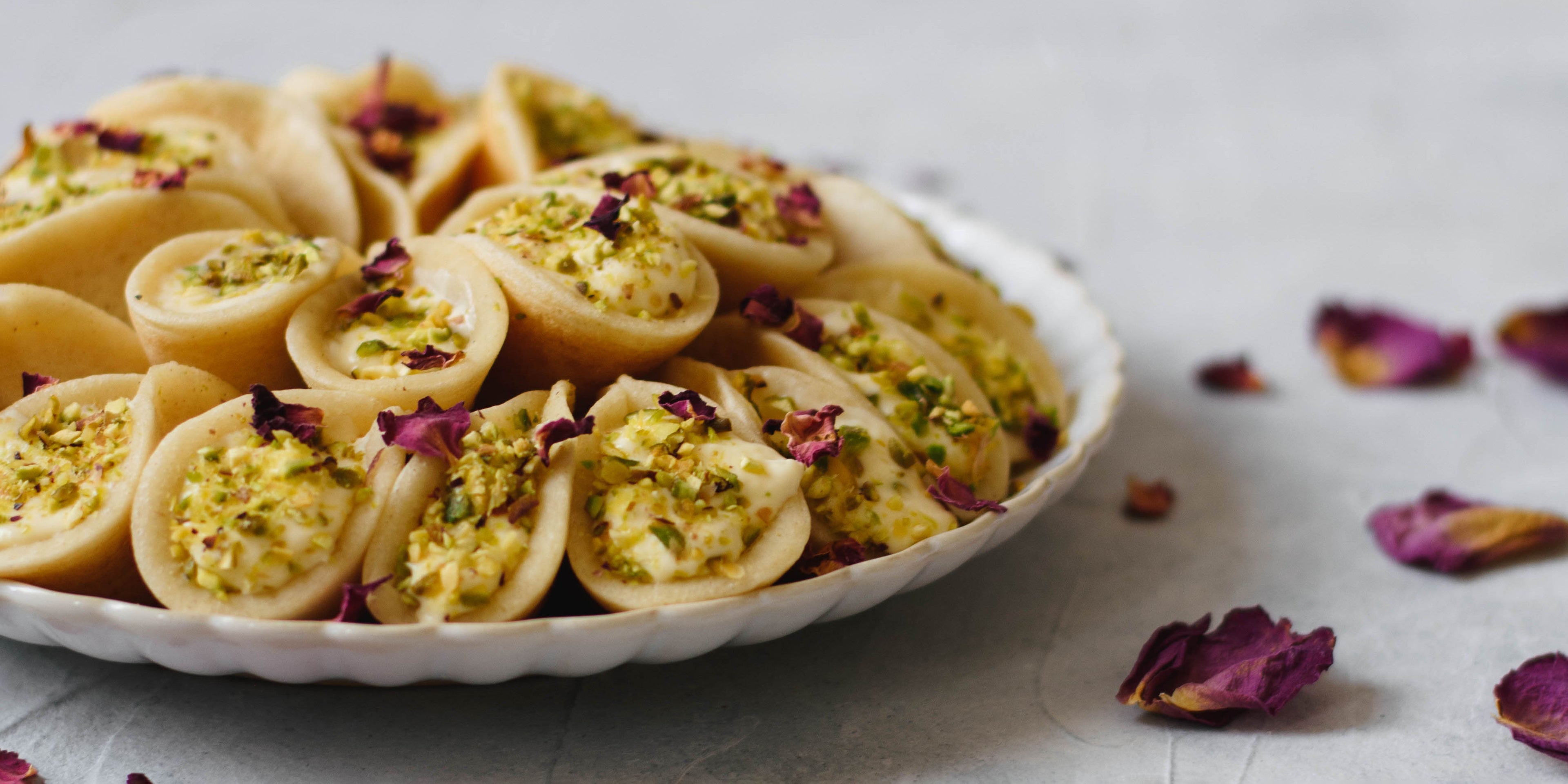 Qatayef on a plate next to petals for decoration