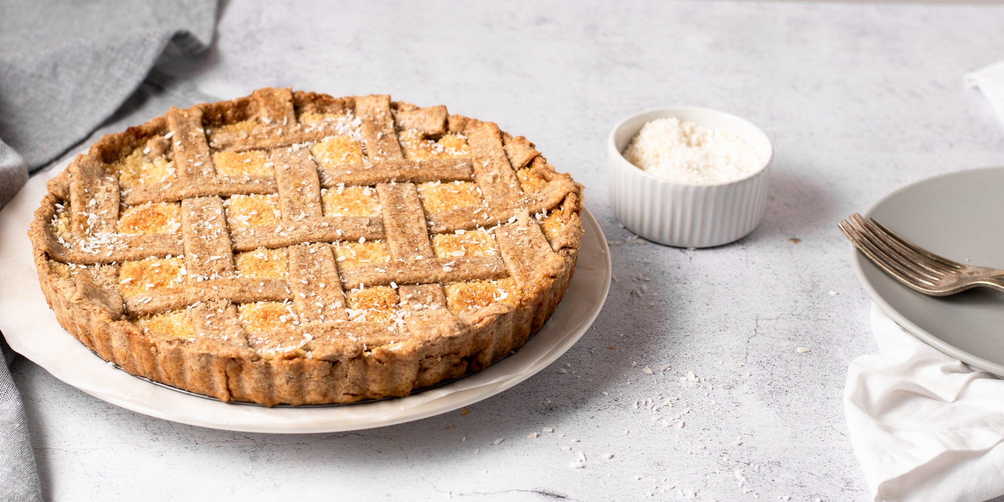 Coconut tart next to a bowl of dried coconut