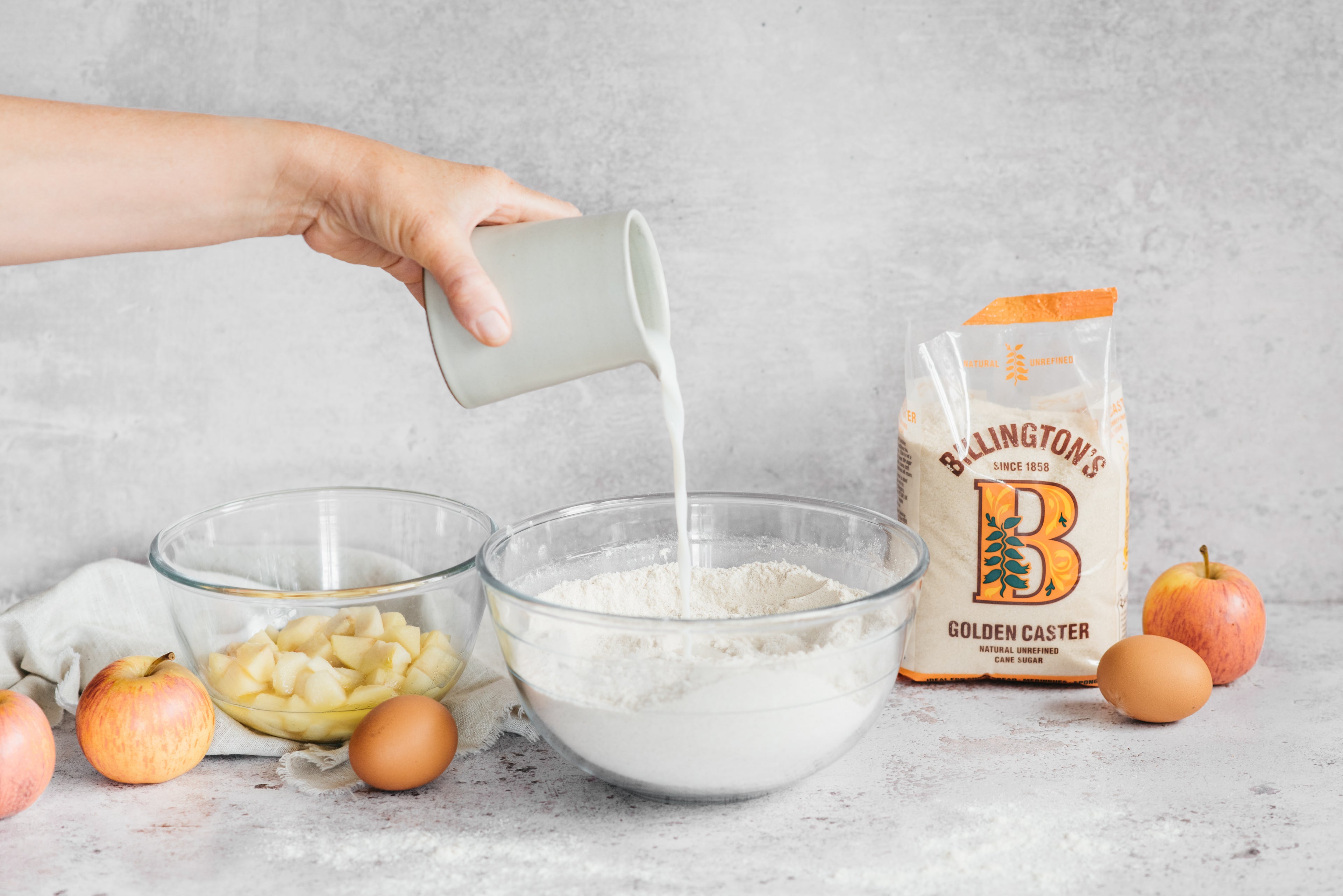 Milk being poured into a bowl of flour