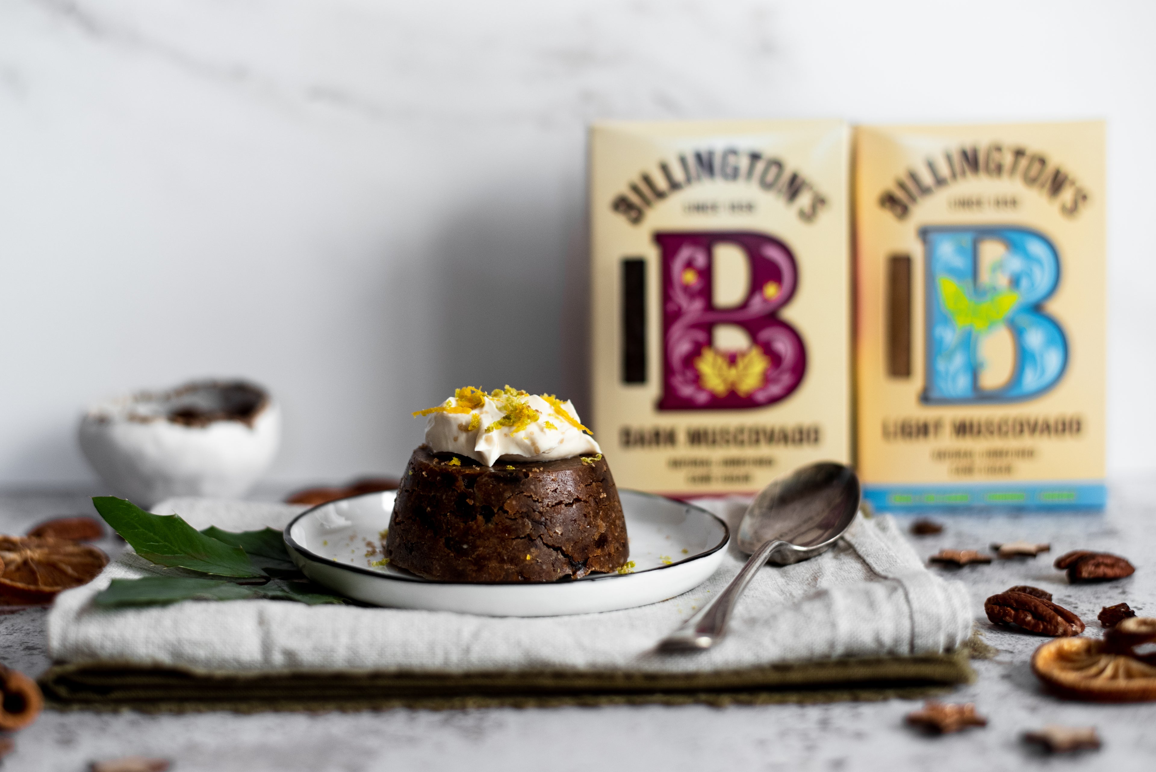 Mini Christmas Pudding with mascarpone topping and two boxes of sugar in background