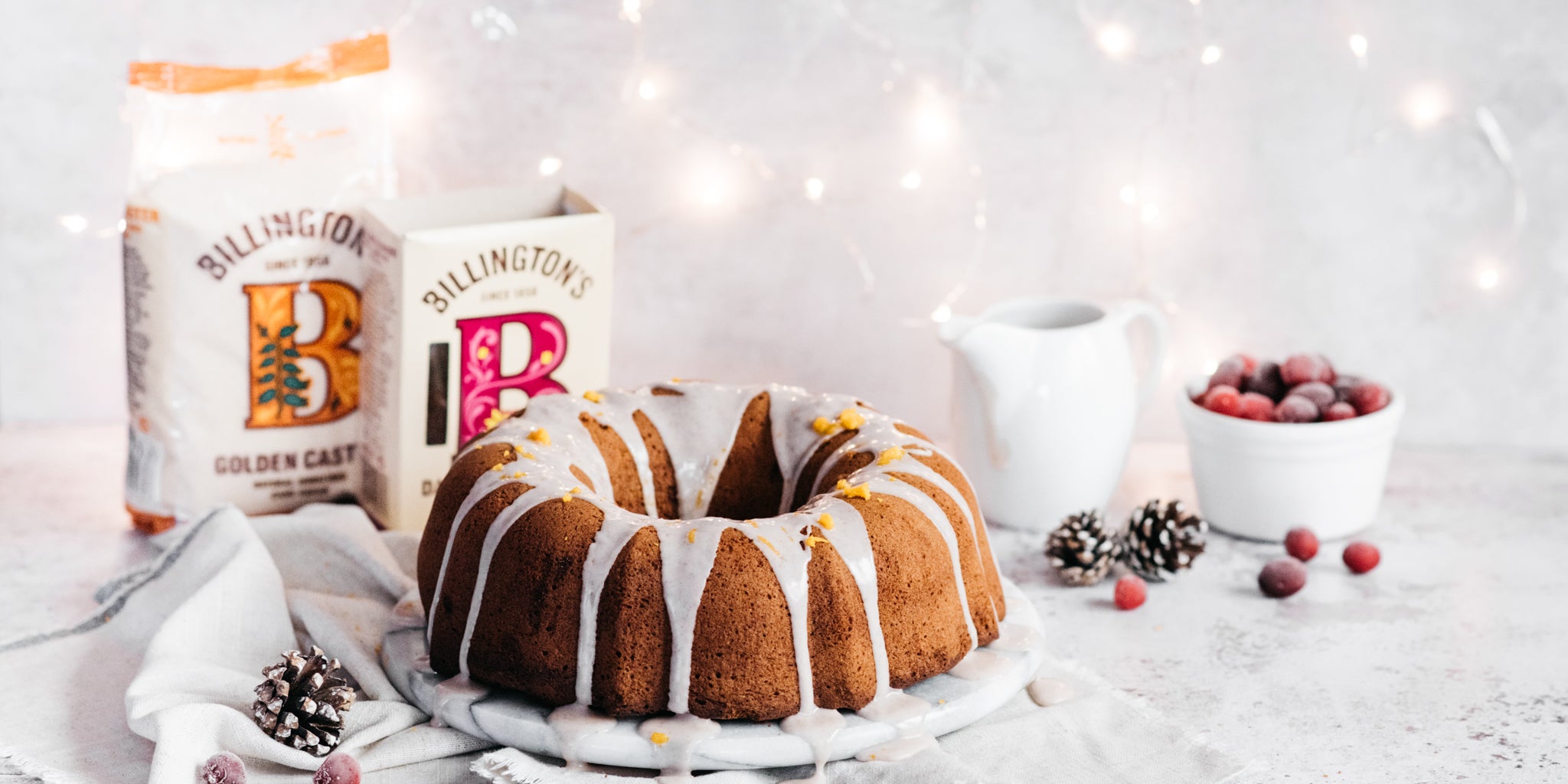 Gingerbread bundt cake with drizzling icing and sugar packs in background