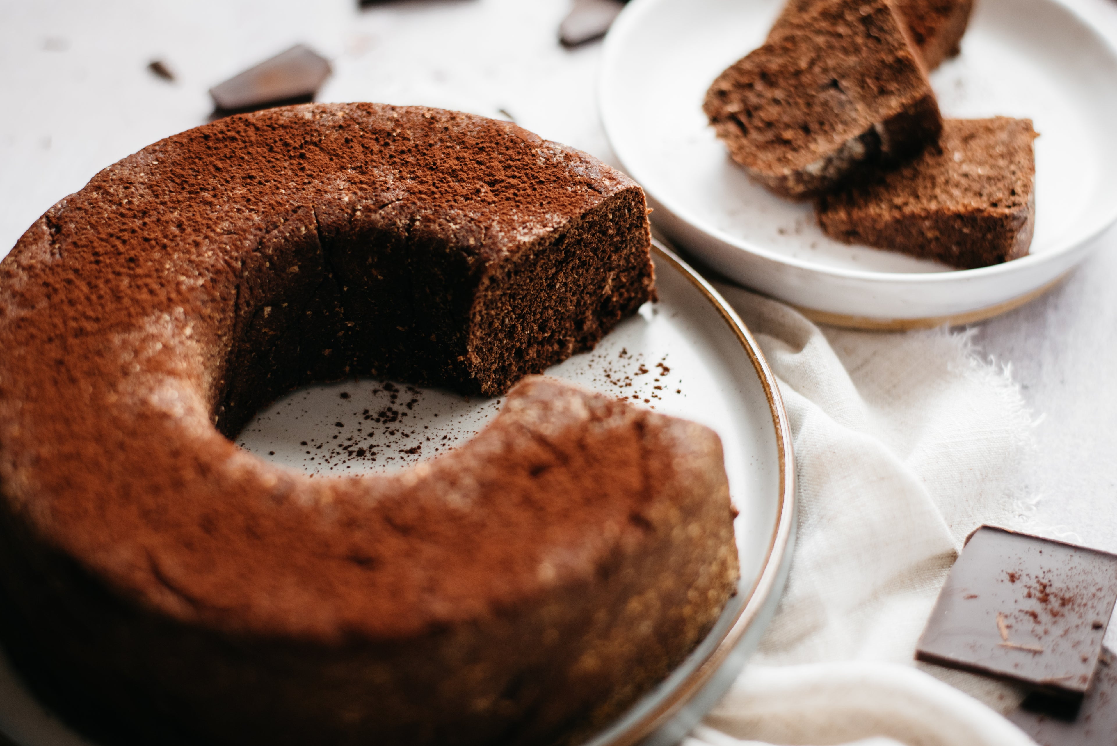 Close up of Chocolate Bread with slice cut out of it and served on a plate in the background