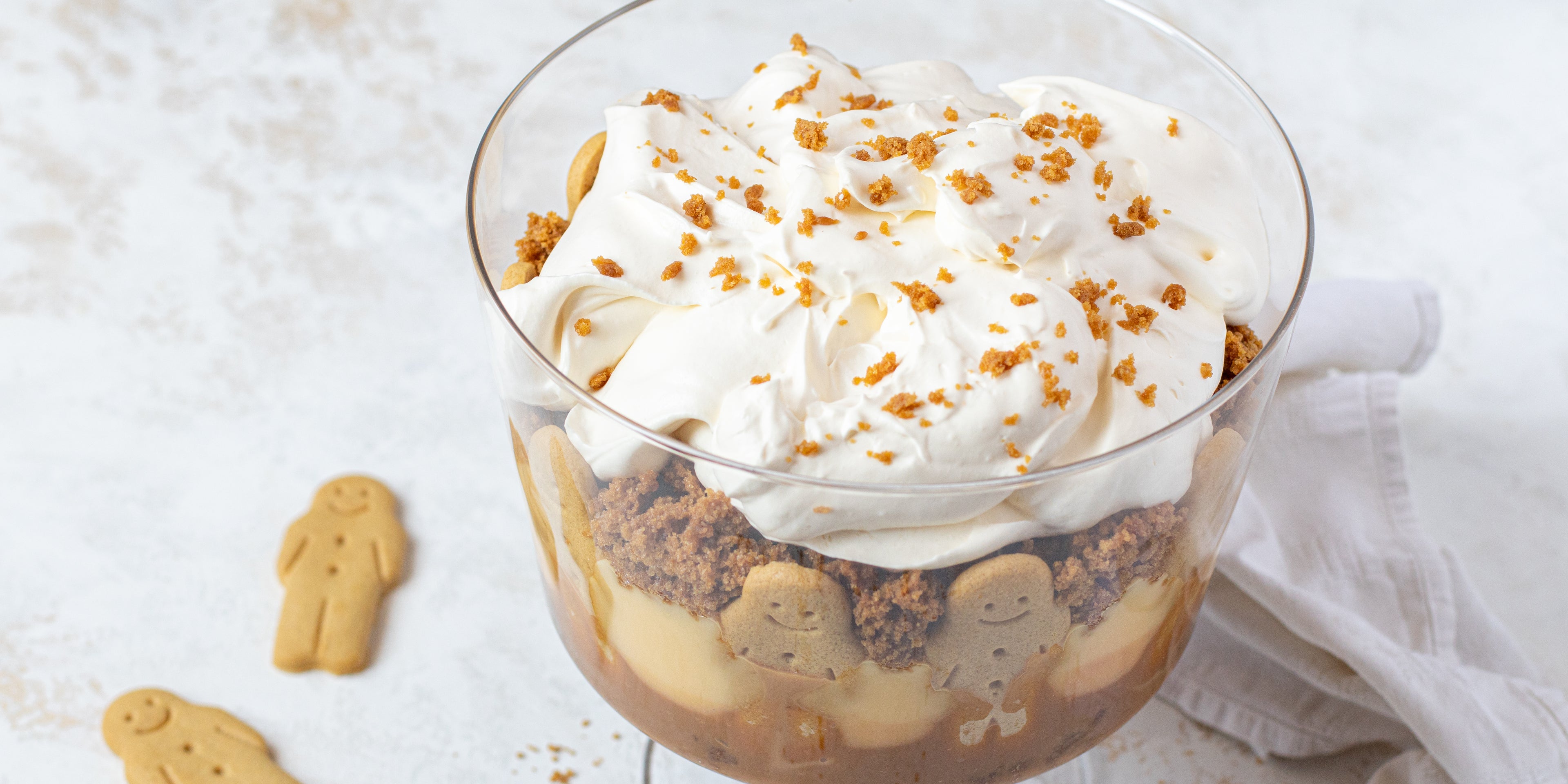 Top view of Gingerbread Trifle sprinkled with gingerbread crumbs. Gingerbread men scattered around the trifle