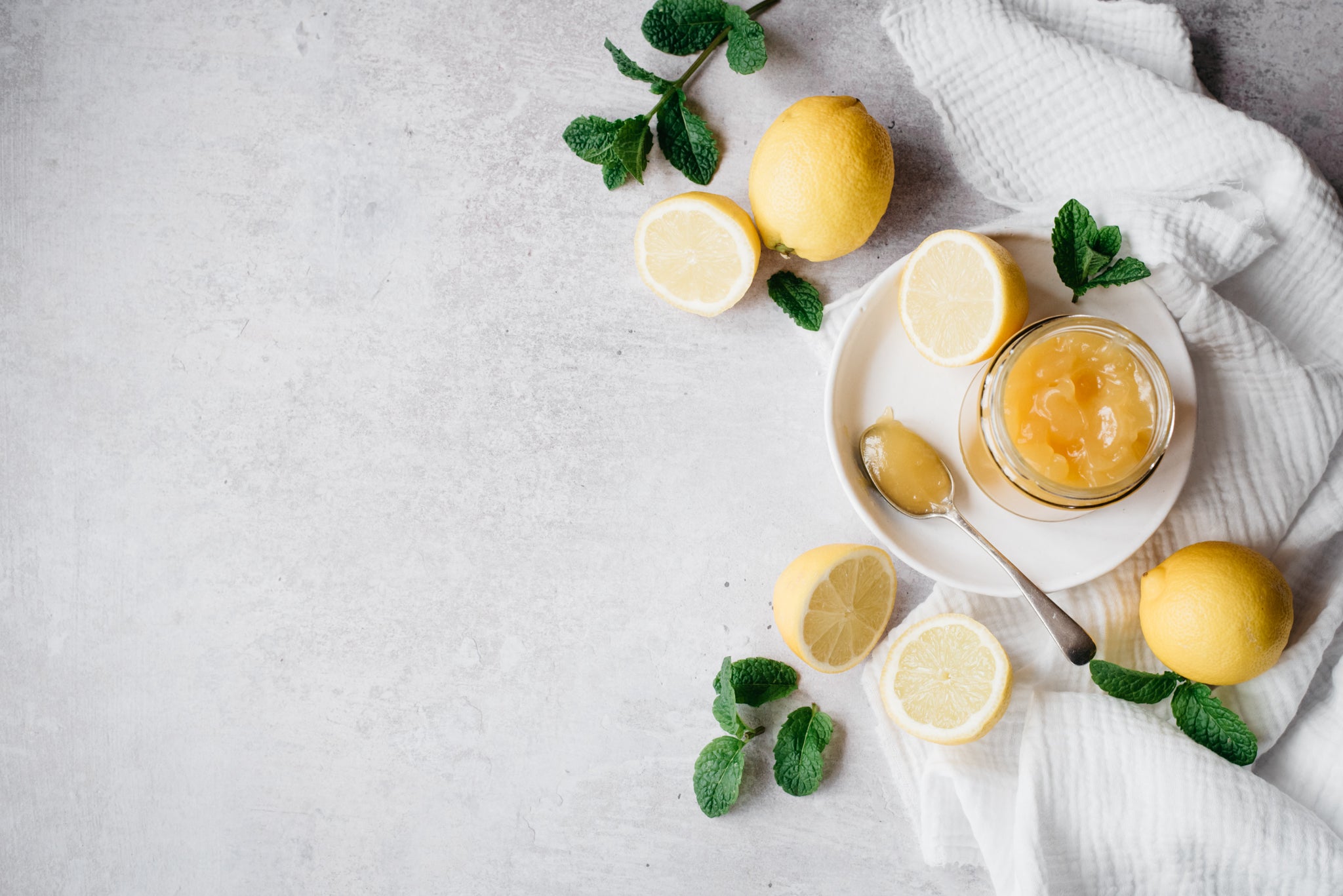 Lemon Curd in a jar next to lemons