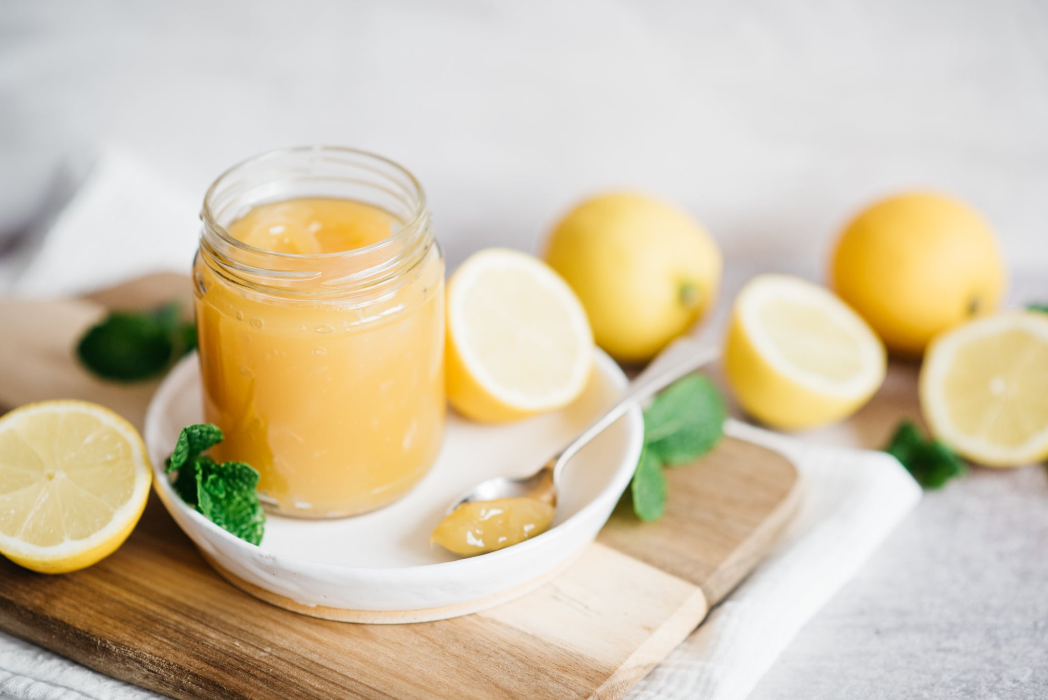 Lemon Curd in a jar next to lemons