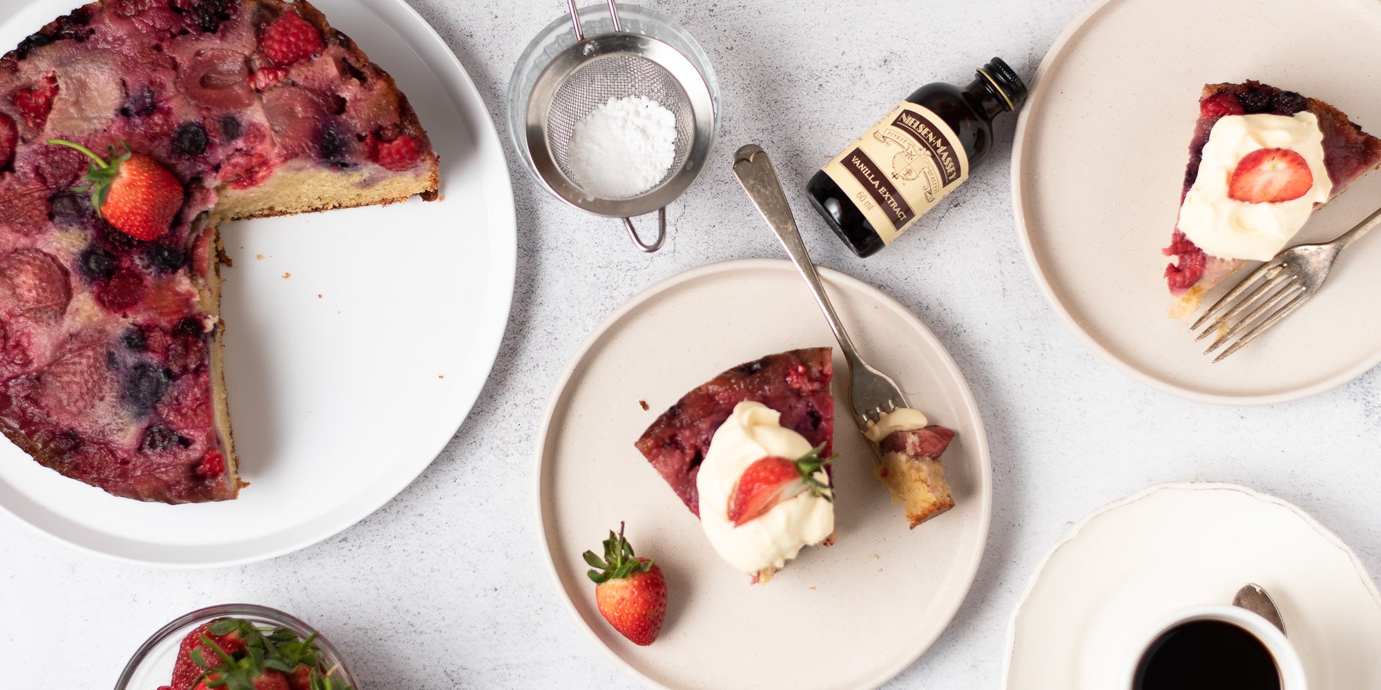 upside down berry pudding on a plate topped with two strawberries