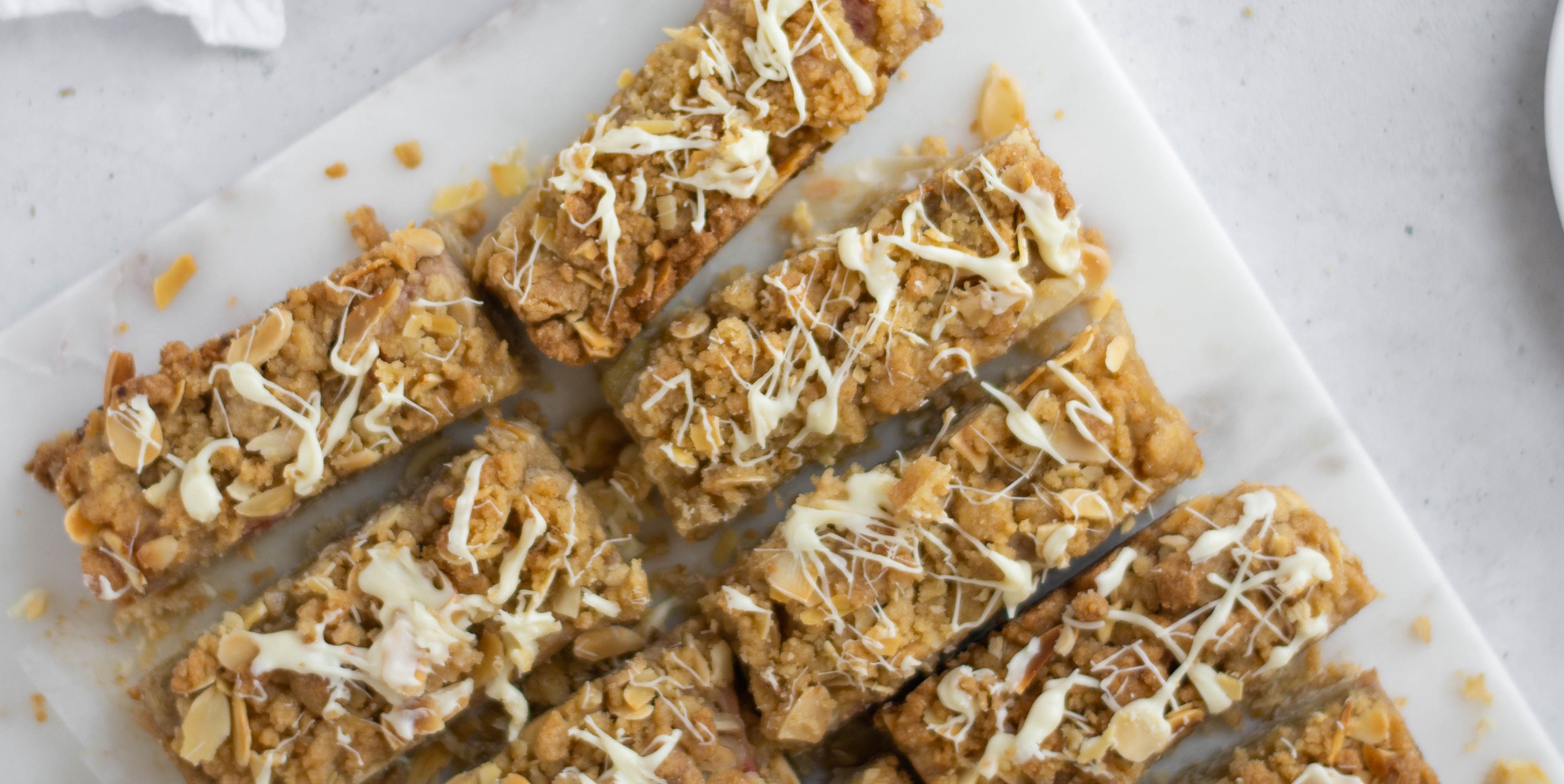 Close up of Rhubarb Crumble cut into slices drizzled in white chocolate