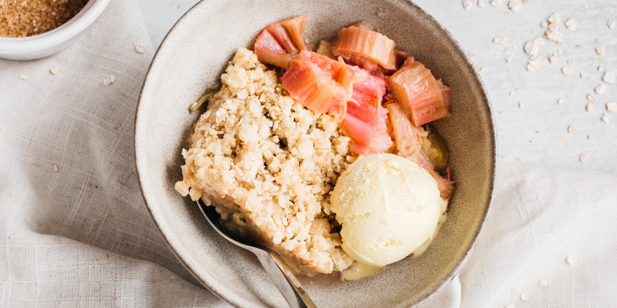 Bowl of rhubarb crumble with scoop of ice cream
