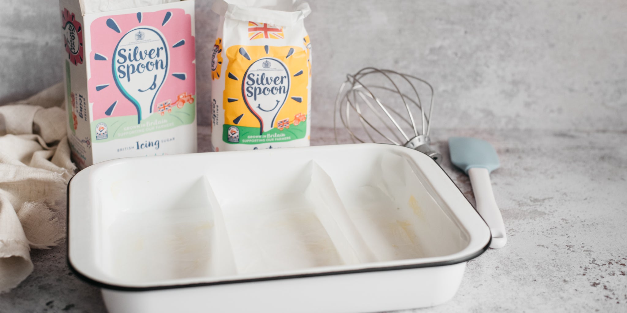 Baking dish prepped with paper and sugar packs in background